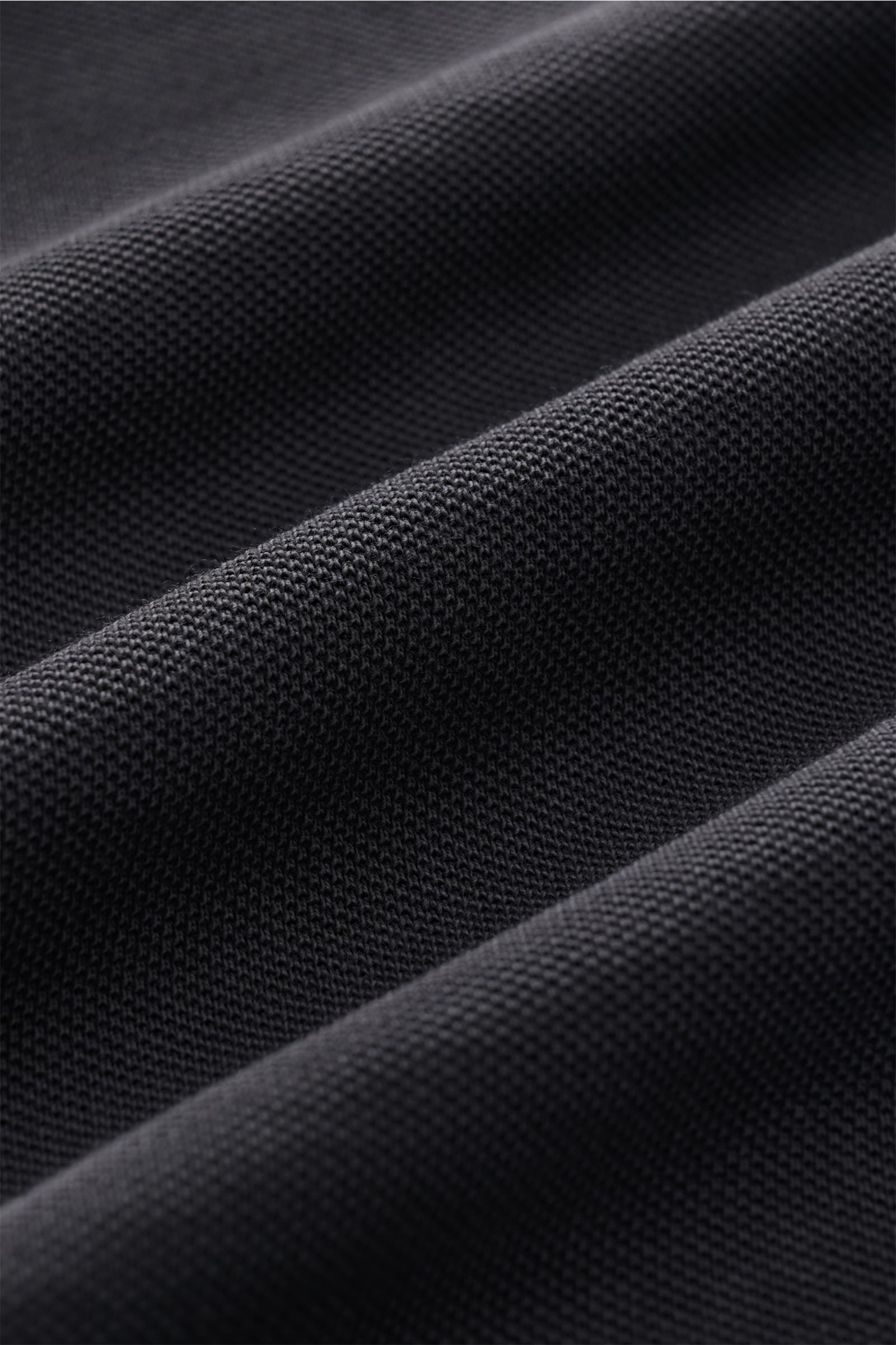 Nahaufnahme des dunkelgrauen Della Ciana Piqué-Hemd Haifisch-Kragen Stoffes mit strukturierter Baumwoll-Piqué-Oberfläche, handgefertigt in Italien, Perspektive schräg von oben.