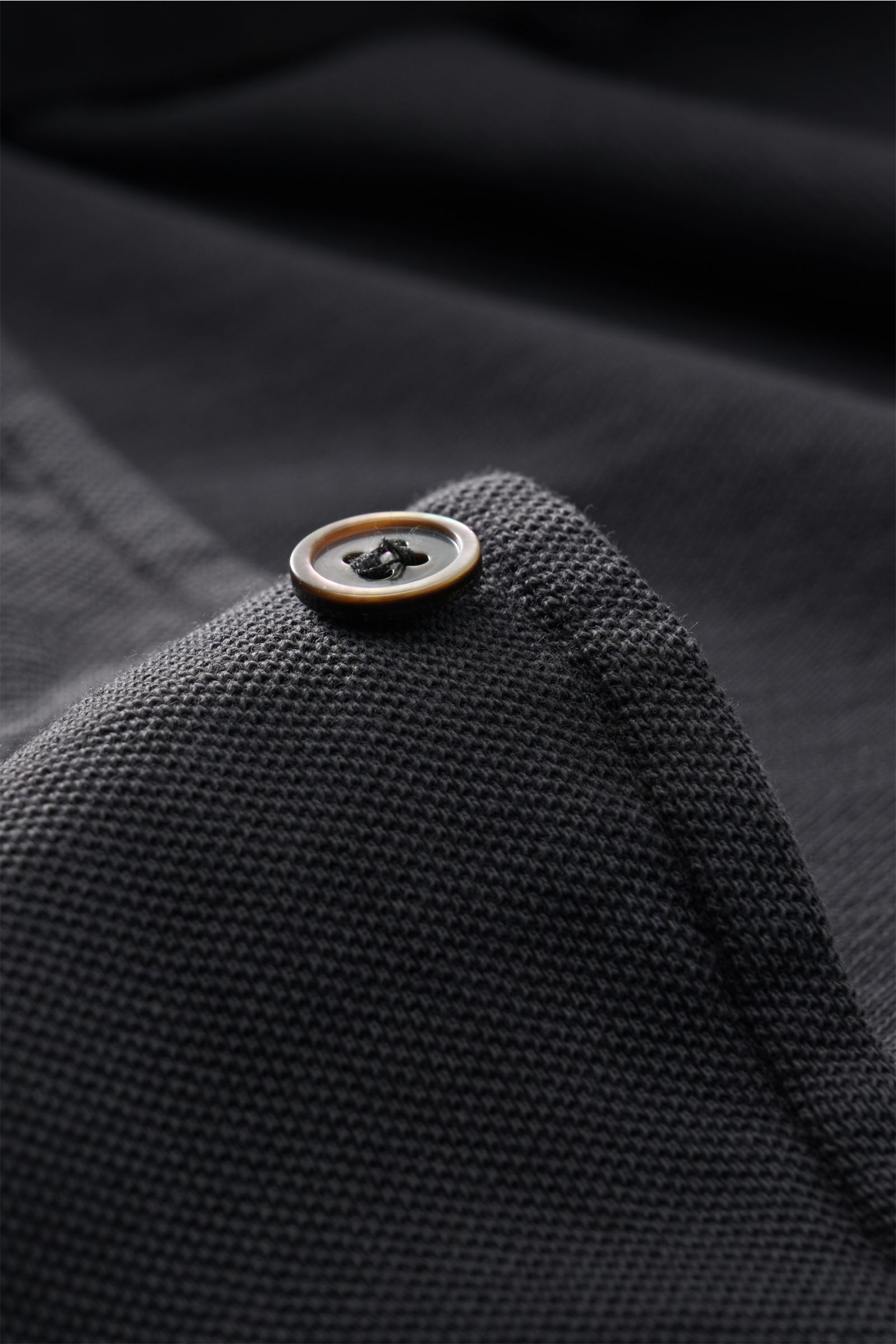 Nahaufnahme eines Knopfes und der Struktur des Della Ciana Piqué-Hemd Haifisch-Kragen dunkelgrau, handgefertigt aus Baumwoll-Piqué mit Vintage-Charakter.