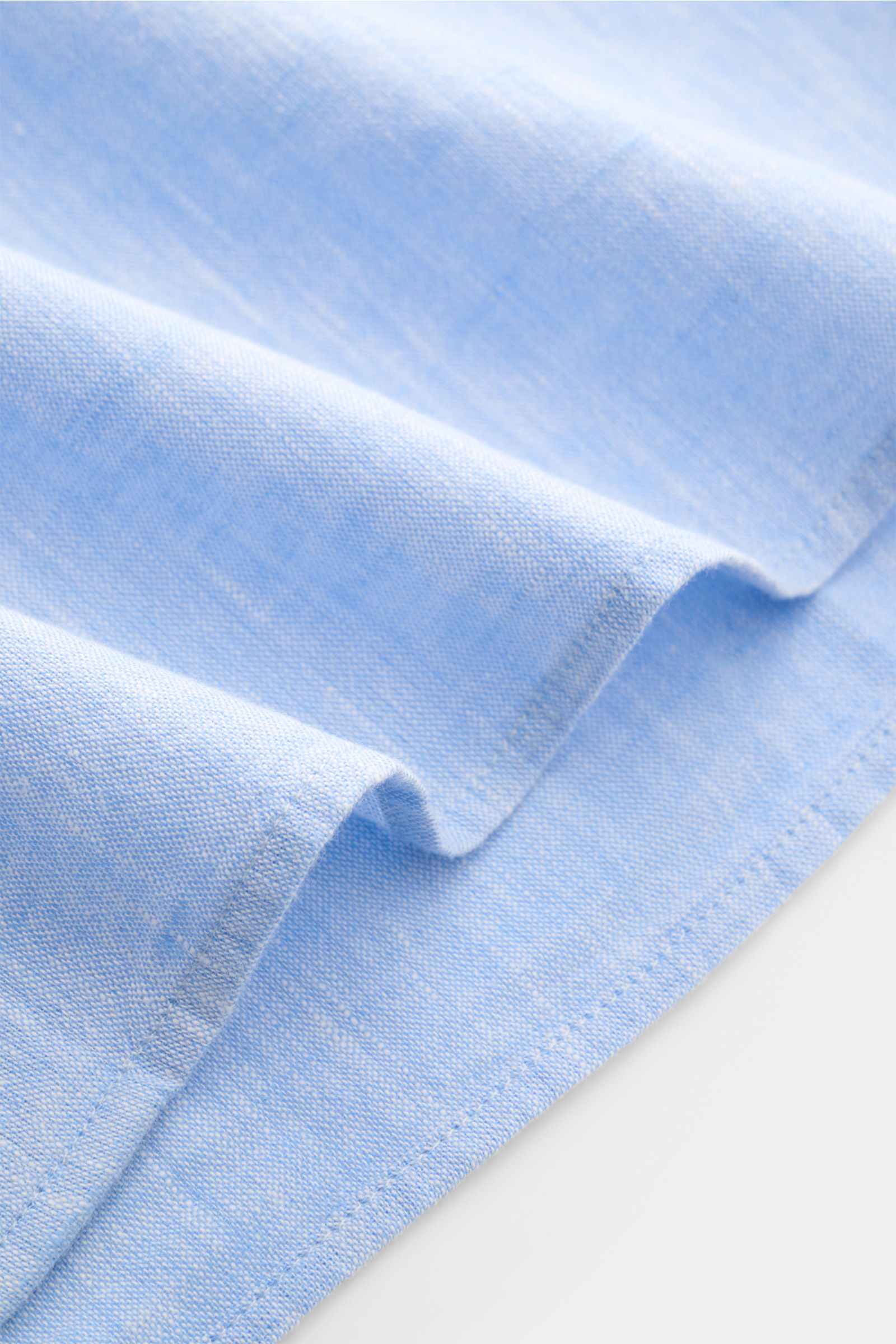Officine Générale Casual Hemd 'Guido' Kent-Kragen hellblau meliert, Detailaufnahme des weichen Baumwollstoffs in Leinwandbindung mit leicht gerundetem Saum.