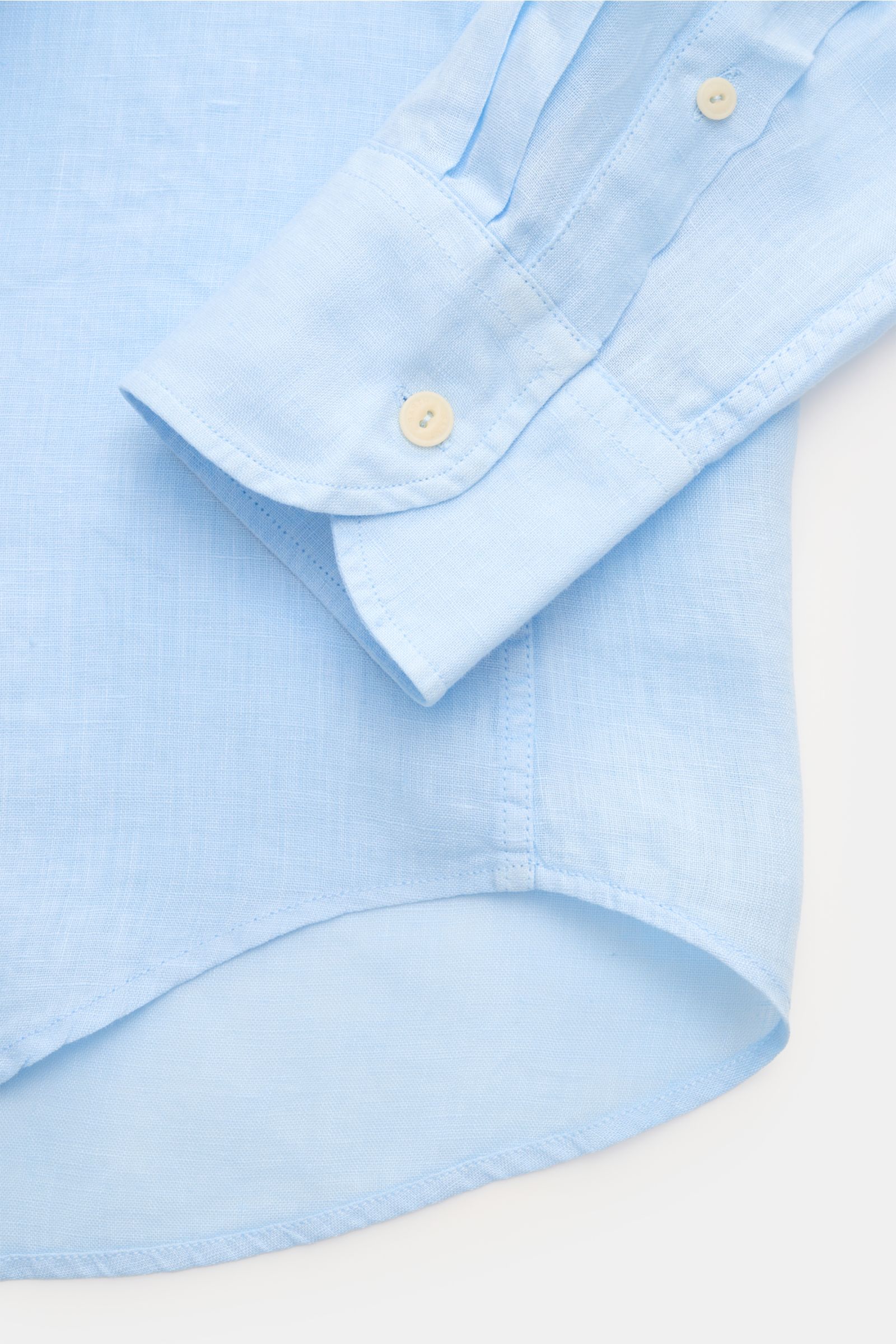 Close-up of the cuff and rounded hem of the MC2 Saint Barth Linen shirt 'Pamplona' shark collar light blue, photographed from above.

With this airy, lightweight shirt in pure linen, MC2 SAINT BARTH brings us a perfect piece for casual summer looks.