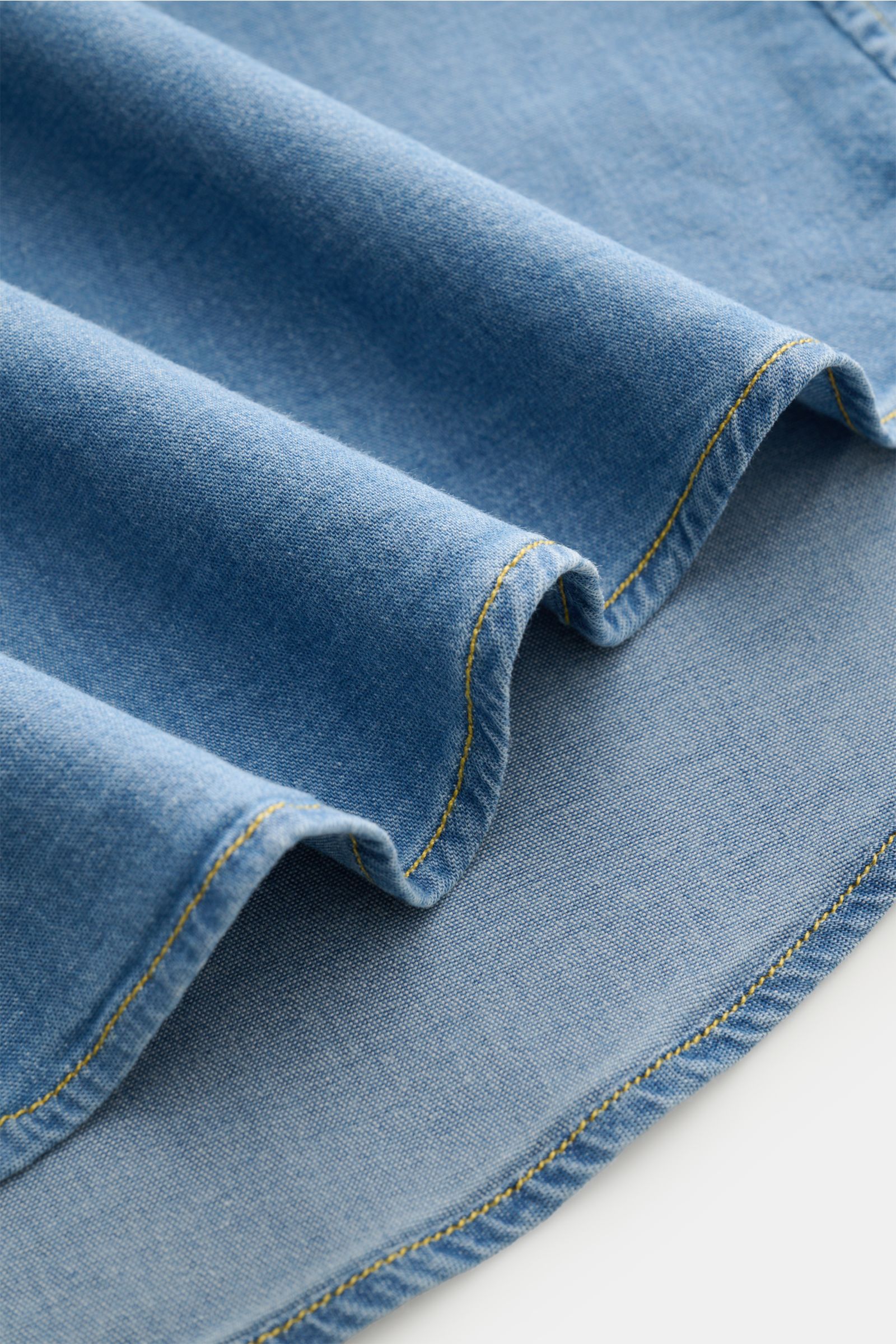 Close-up fabric detail of the Gherardi Chambray shirt Kent collar smoky blue, showing soft, stretchy cotton chambray with denim look and yellow stitching from a top-down perspective.

Casual chambray shirt by experts GHERARDI: This model in soft, stret