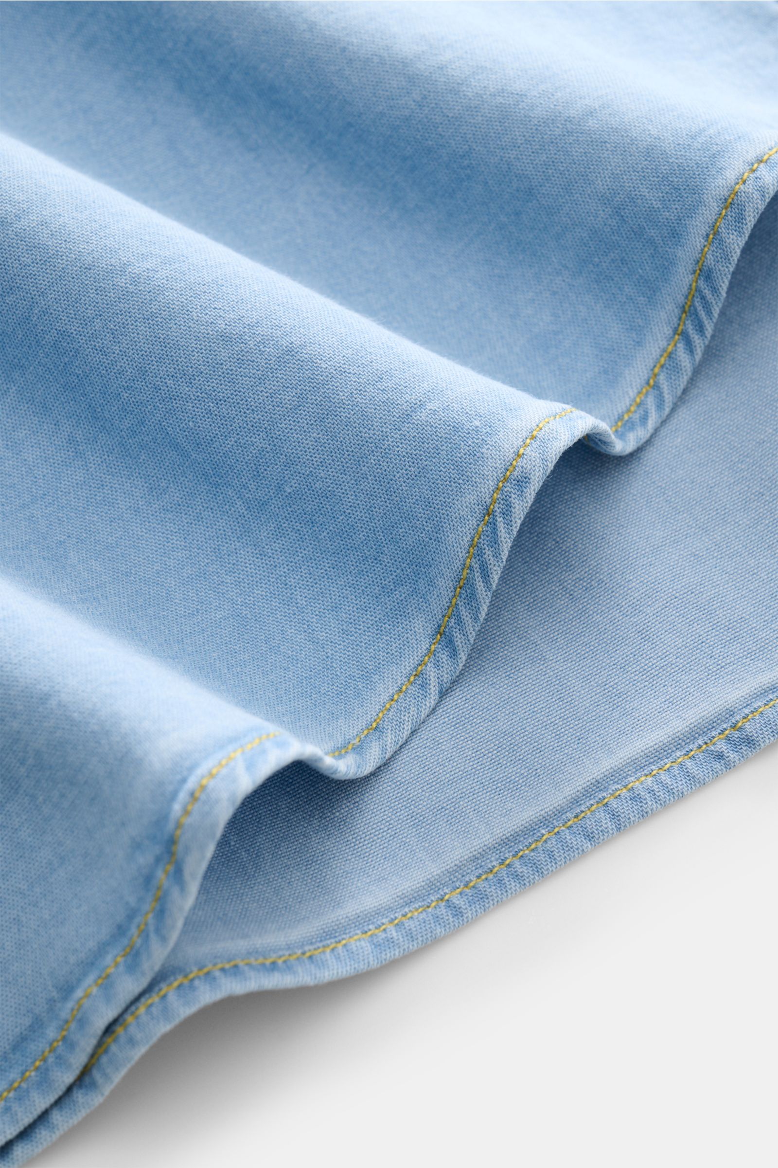 Close-up front view of the soft, light blue fabric of the Gherardi Chambray-Hemd Kent-Kragen hellblau, showing detailed stitching and texture.

Description: Legeres Chambray-Hemd vom Experten GHERARDI: Dieses Modell aus softer, elastischer Baumwolle in