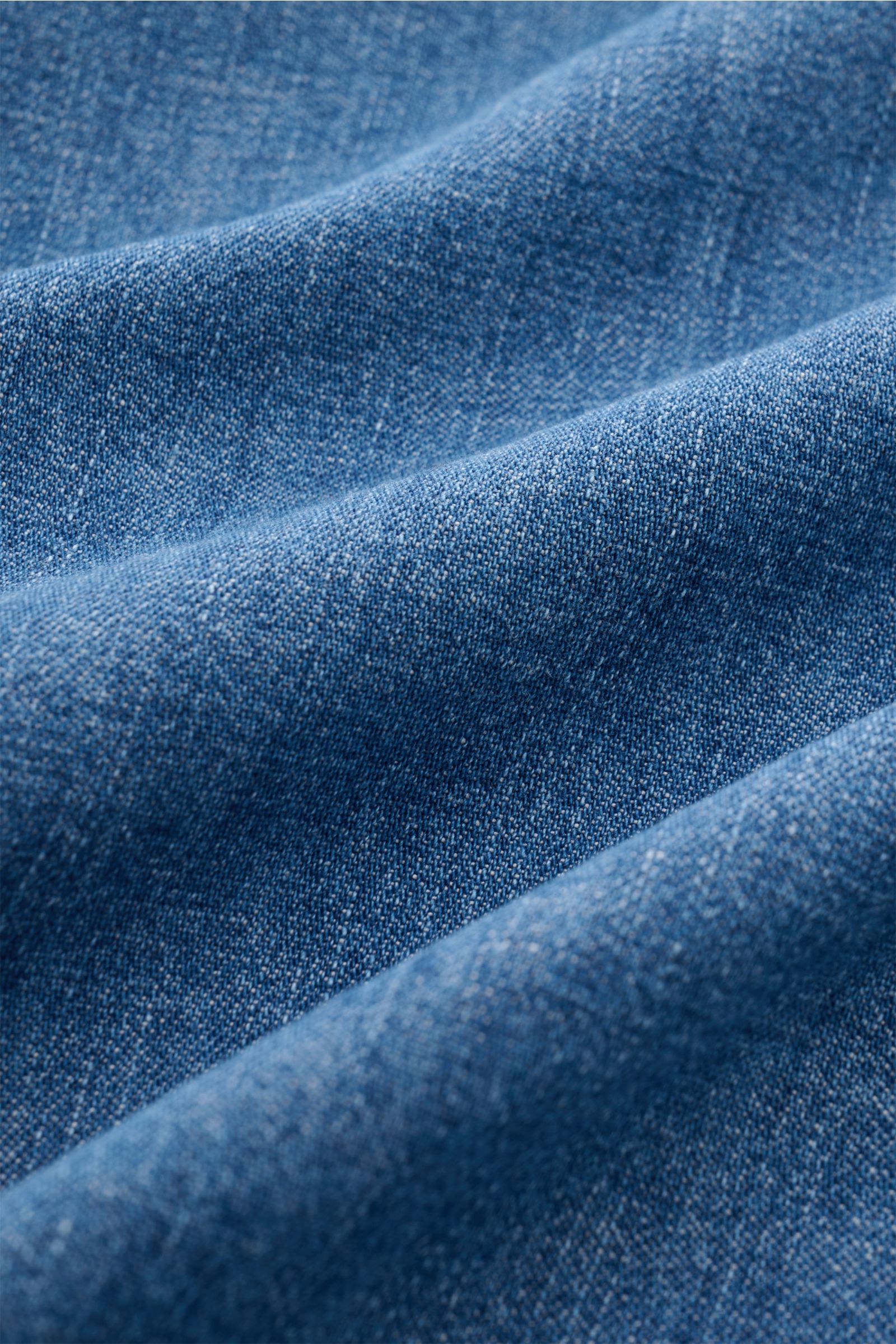 Das Bild zeigt eine Nahaufnahme des hochwertigen Denim-Stoffs vom Dondup Jeanshemd 'Camicia' Kent-Kragen blau mit weichem Griff und moderner Western-Optik.