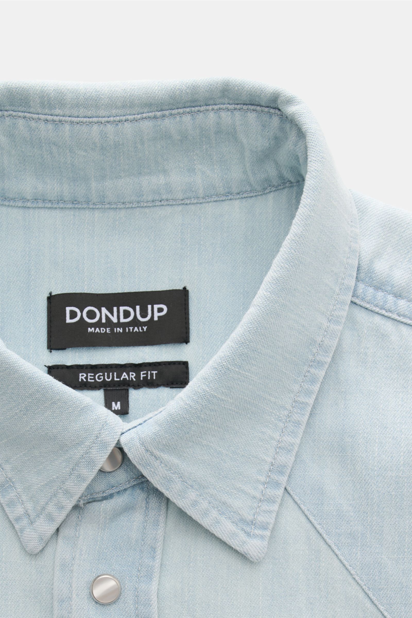 Close-up front view of Dondup Jeanshemd Kent-Kragen pastellblau, a slim fit, pastel blue denim shirt with Kent collar, snap button placket, and soft pure cotton fabric.

Additional description for context: 
Modernes Denim Statement: Das Jeanshemd von D