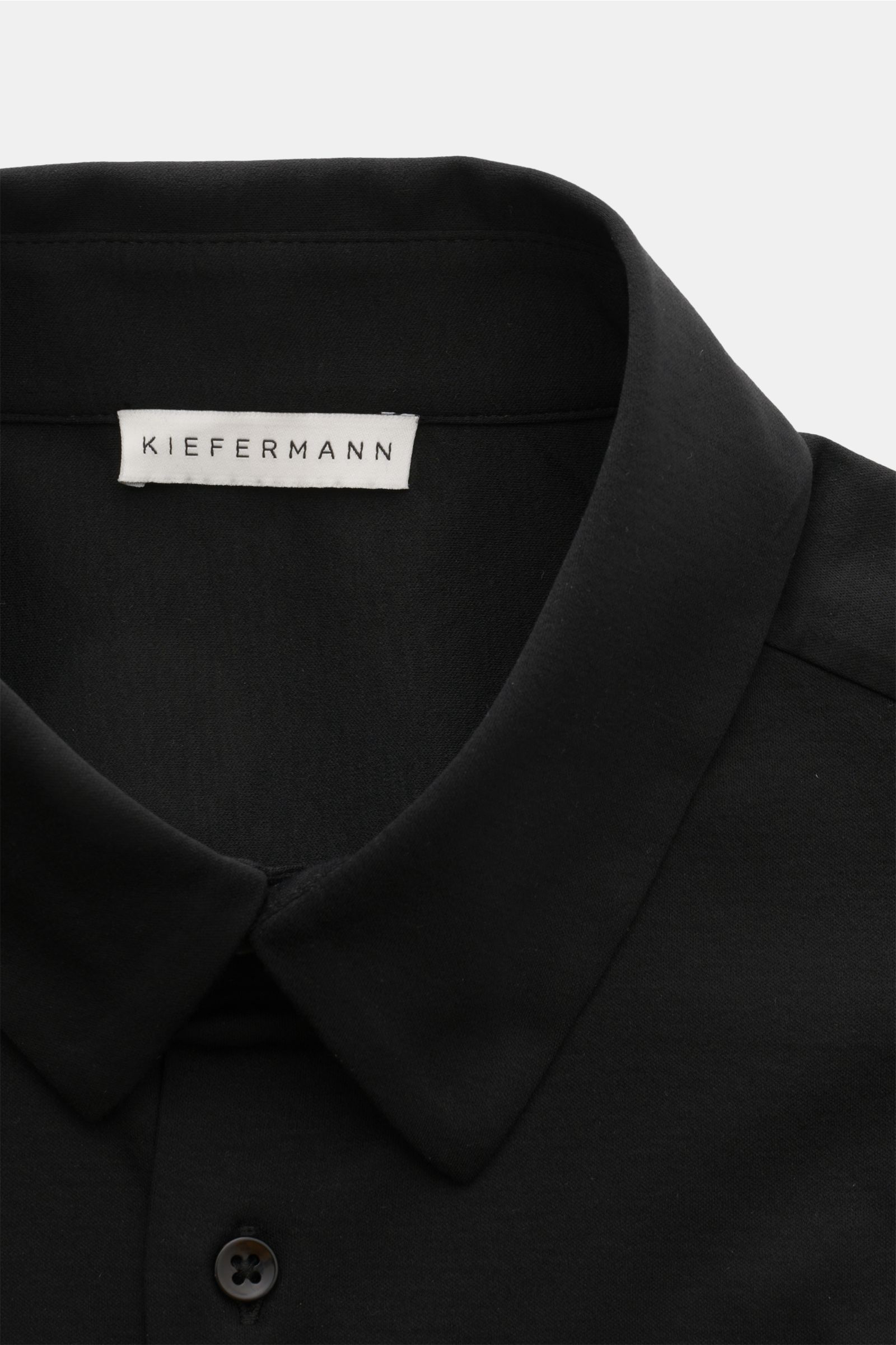 Nahaufnahme des schwarzen Kiefermann Jersey-Hemd 'Pius' Kent-Kragen schwarz mit mercerisierter Baumwolle, extra Slim Fit und französischer Knopfleiste, von oben fotografiert.