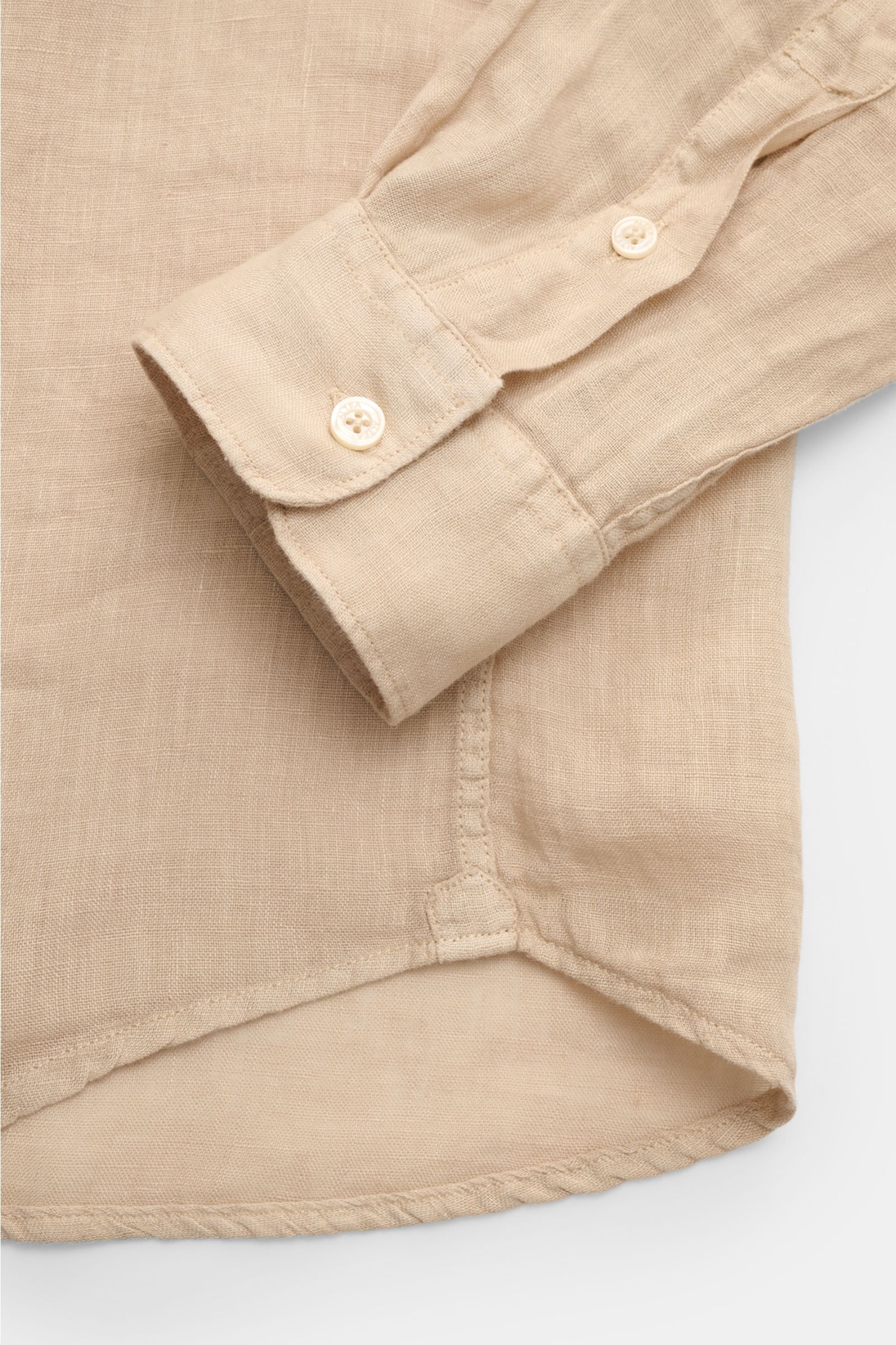 Nahaufnahme des gerundeten Saumverlaufs und der klassisch sportlichen Manschette des Altea Leinenhemd 'Mercer' Haifisch-Kragen beige aus reiner, leichter Leinen-Gaze.