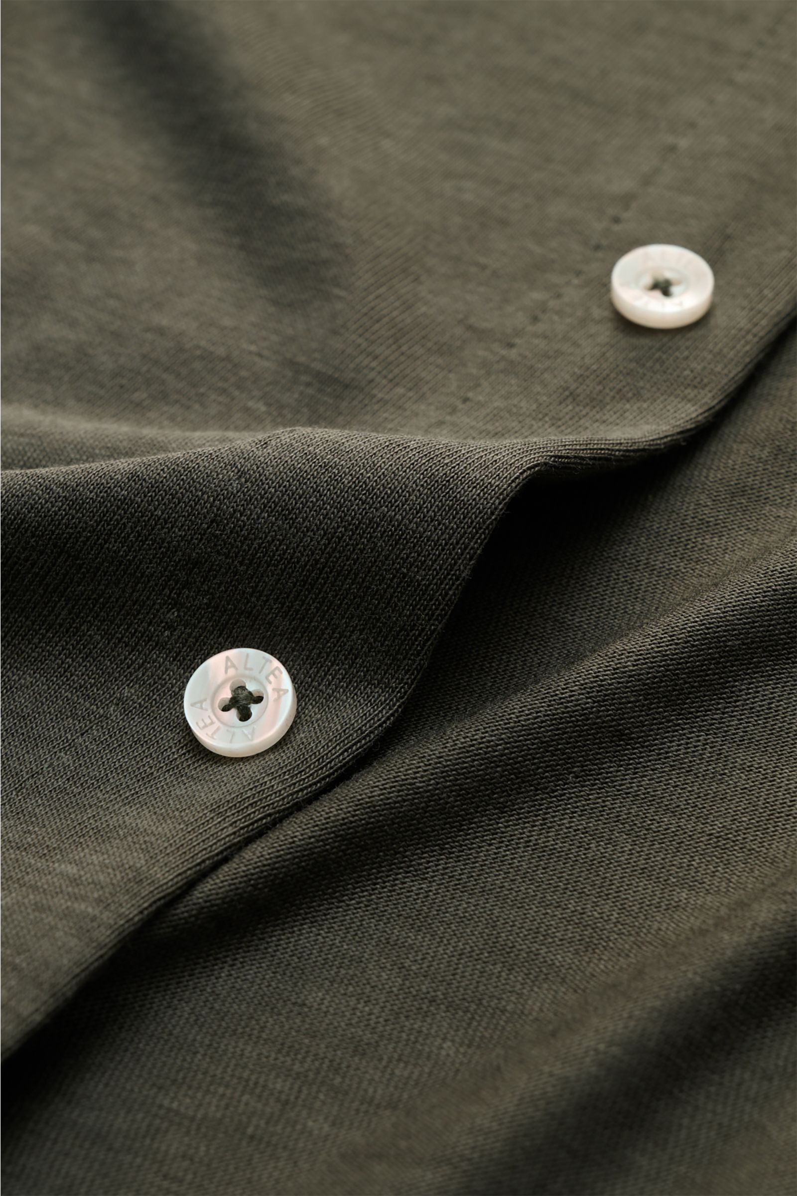 Nahaufnahme des Altea Jersey-Hemd 'Julius' Polokragen dark olive mit weichem Jersey, glatter Knopfleiste und feinem Stoff aus Lyocell-Baumwolle-Mix.