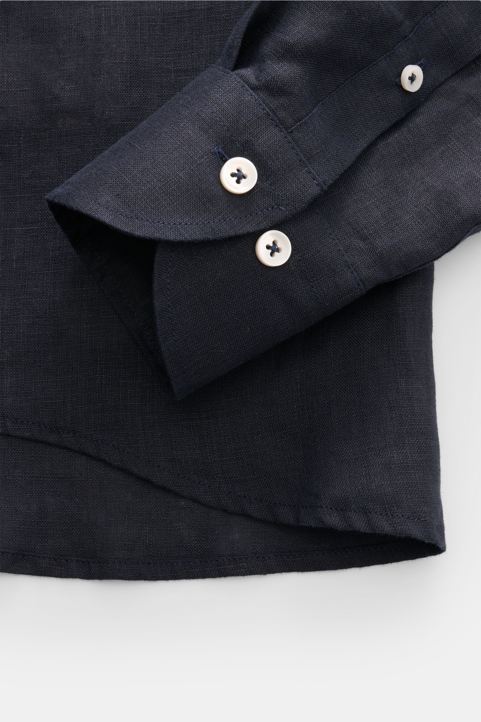 Close-up front view of Aurélien Linen shirt shark collar dark navy showing sleeve with white buttons and rounded hem in fine linen fabric.

Want to get into the holiday mood? With its fine linen fabric, this versatile shirt by the brand AURÉLIEN is an 