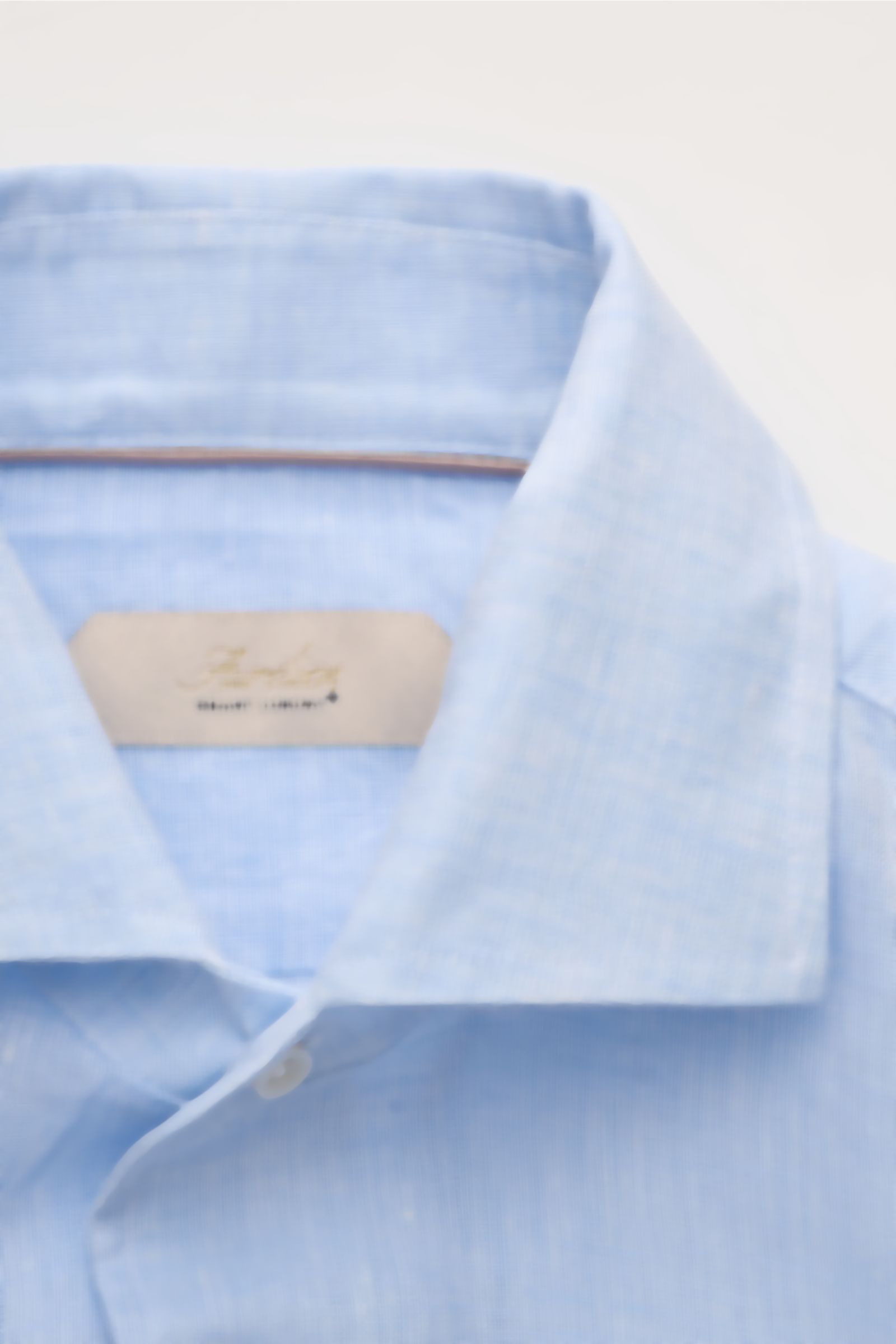 Nahaufnahme aus schräger Perspektive des hellblauen Aurélien Leinenhemd Haifisch-Kragen mit feinem Leinengewebe, Slim Fit, französischer Knopfleiste, klassischer Sportmanschette, rückwärtigen Taillenabnähern und gerundetem Saum für Büro und Freizeit.