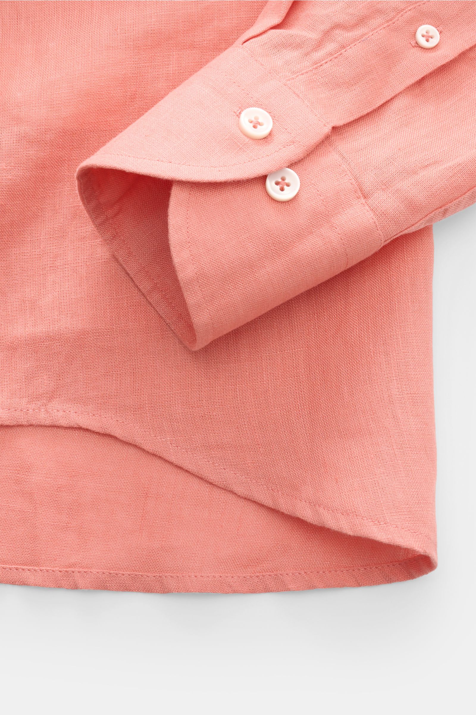 Close-up of the Aurélien Linen shirt shark collar coral showing the sleeve cuff and rounded hem from a top-down perspective.

Want to get into the holiday mood? With its fine linen fabric, this versatile shirt by the brand AURÉLIEN is an all-rounder fo