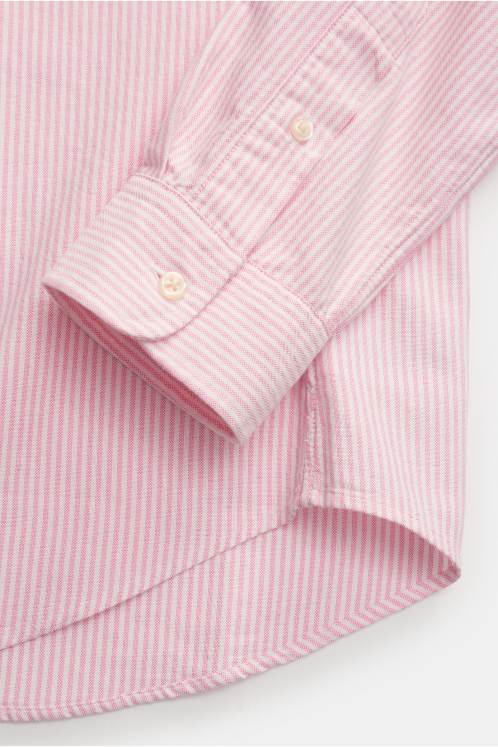 Close-up view of the Polo Ralph Lauren Oxfordhemd Button-Down-Kragen rosé/weiß gestreift sleeve and curved hem, showing slim fit, multicolor stitching, and soft cotton fabric.

Zeitloser Allrounder: Das Oxford-Hemd von POLO RALPH LAUREN verbindet klass