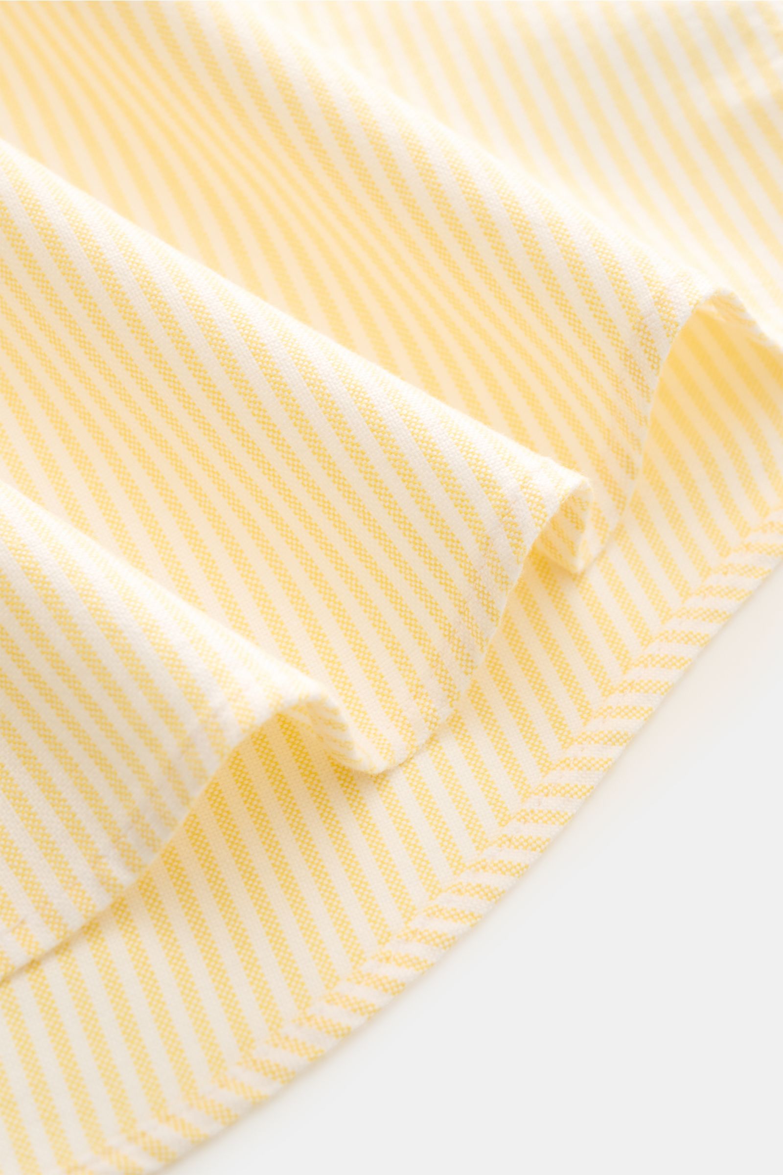 Close-up, angled view of Polo Ralph Lauren Oxford-Hemd Button-Down-Kragen gelb/weiß gestreift fabric showing fine yellow and white stripes. Stilvoller Klassiker mit Liebe zum Detail: Dieses sportliche Hemd von POLO RALPH LAUREN aus reiner Baumwolle mit