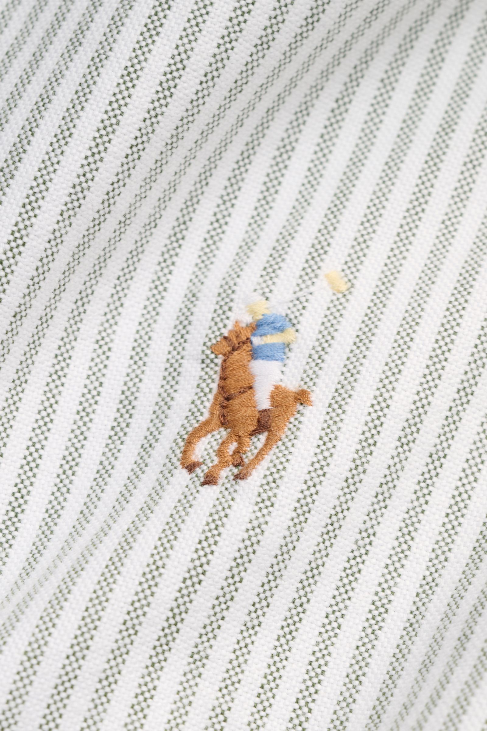 Close-up front view of Polo Ralph Lauren Oxford shirt button-down collar dark green/white striped fabric, showing multicoloured polo player stitching.

A stylish classic with attention to detail: This sporty shirt by POLO RALPH LAUREN made of pure cott