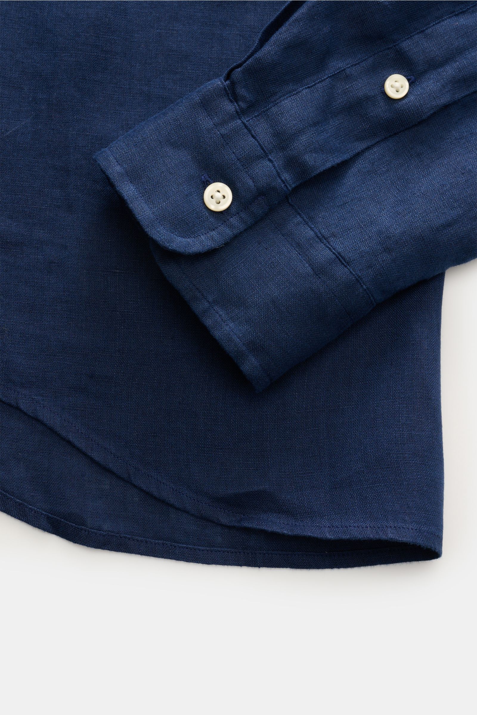 Close-up of the sleeve and cuff of the Polo Ralph Lauren Leinenhemd Button-Down-Kragen türkis, photographed from above. Dieses Leinenhemd von POLO RALPH LAUREN ist eine Bereicherung für jede Sommergarderobe und bringt bei unvergleichlich leichtem, luftige