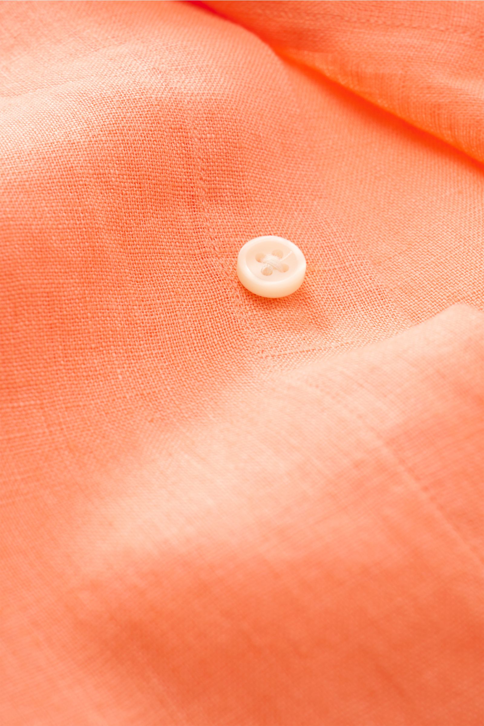 Close-up front view of Polo Ralph Lauren Leinenhemd Button-Down-Kragen orange showing the pure linen fabric texture and a white button, highlighting its lightweight, airy quality with typical Polo stitching and a slim fit design.

Dieses Leinenhemd von