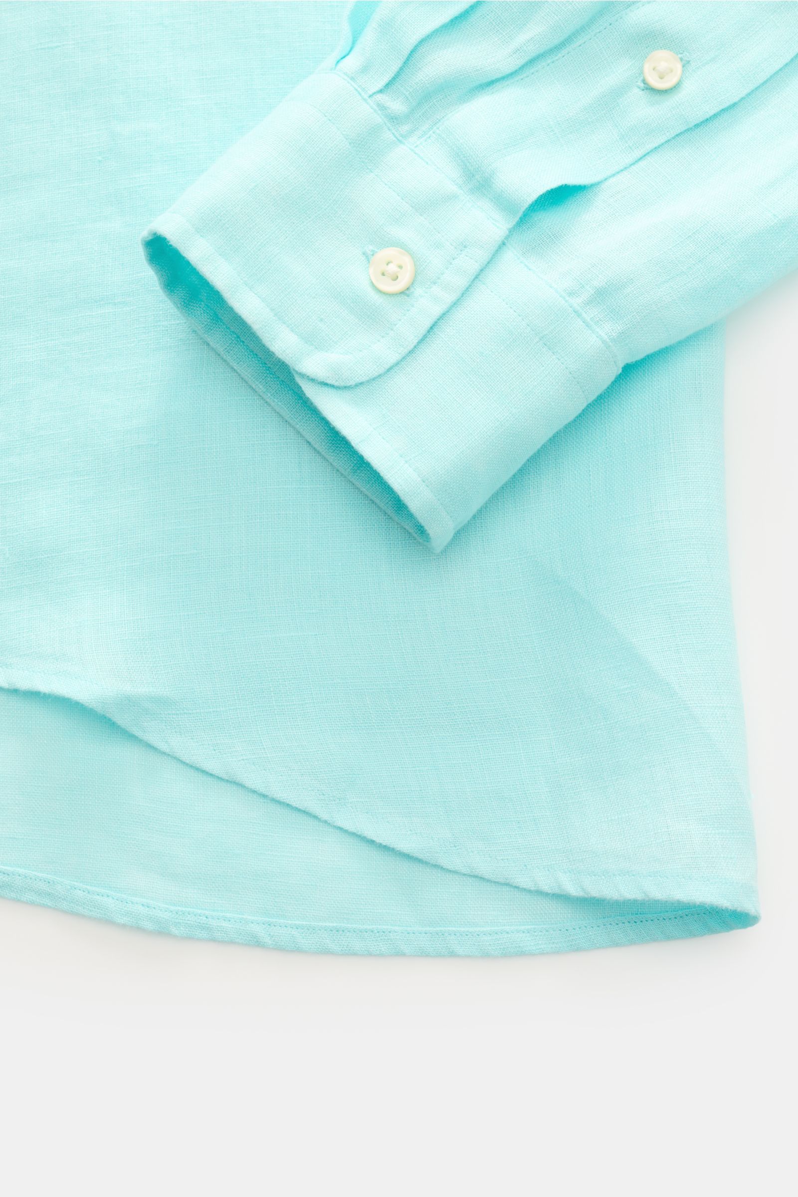 Close-up front view of Polo Ralph Lauren Leinenhemd Button-Down-Kragen türkis cuff and hem, showing light turquoise linen fabric texture and buttons.

Sommerliche Leichtigkeit: Das Leinenhemd von POLO RALPH LAUREN überzeugt mit luftigem Tragegefühl und