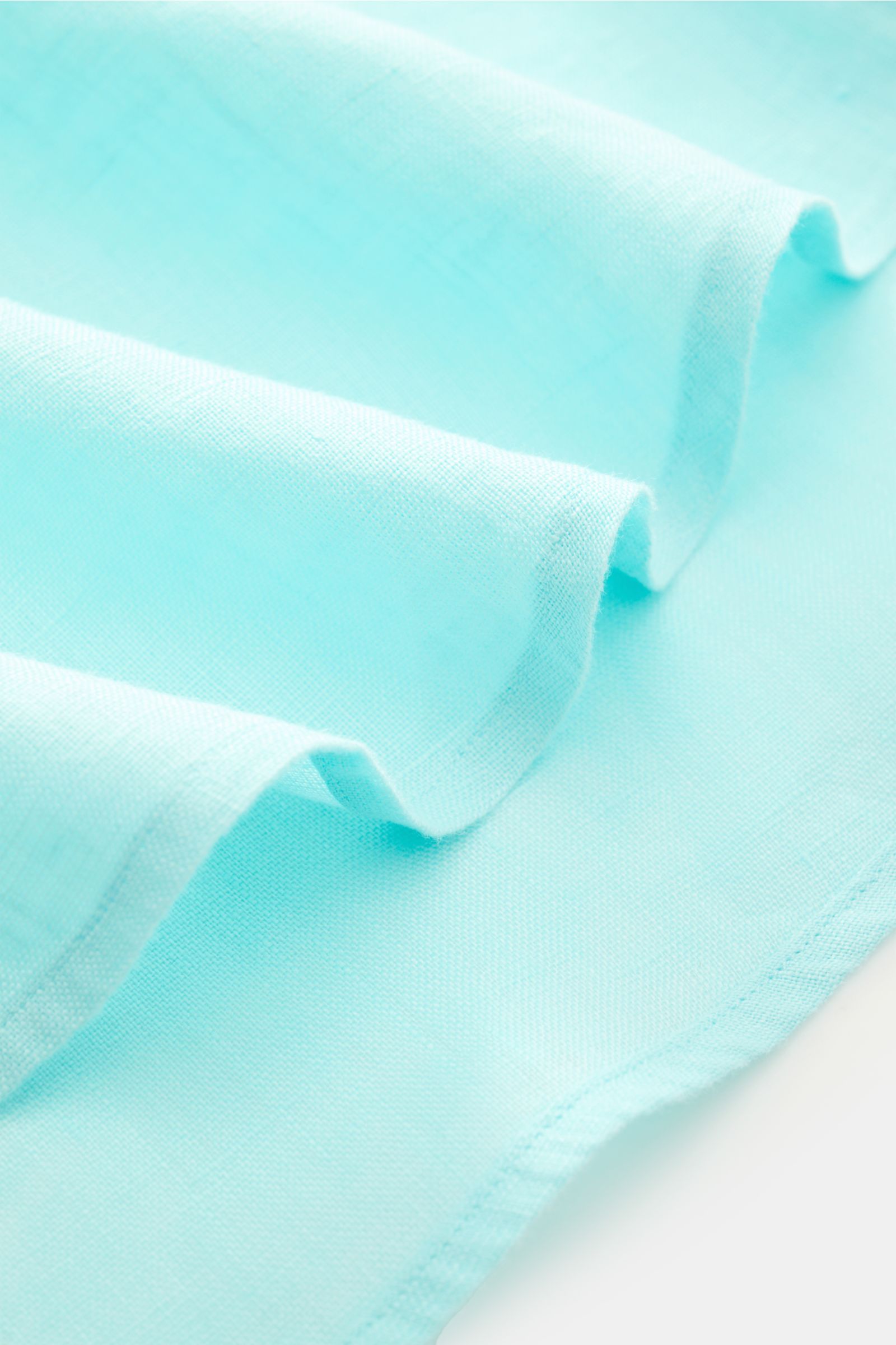 Close-up of turquoise fabric texture showing folds and weave detail, highlighting the light, airy quality of Polo Ralph Lauren Leinenhemd Button-Down-Kragen türkis.

Additional description: 
Sommerliche Leichtigkeit: Das Leinenhemd von POLO RALPH LAURE