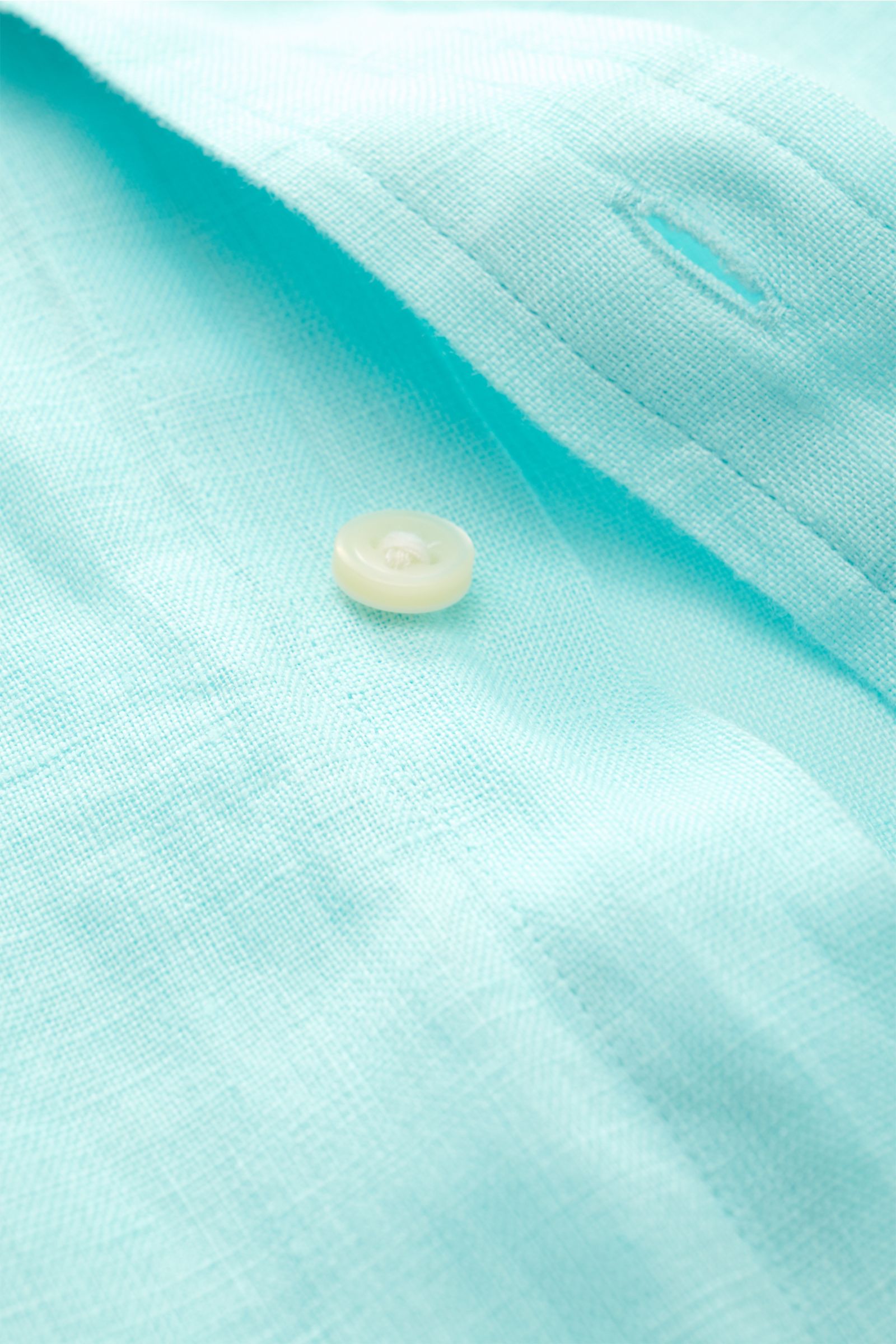 Close-up of a turquoise Polo Ralph Lauren Leinenhemd Button-Down-Kragen showing linen texture, button, and buttonhole from a side angle.

Sommerliche Leichtigkeit: Das Leinenhemd von POLO RALPH LAUREN überzeugt mit luftigem Tragegefühl und entspannt st