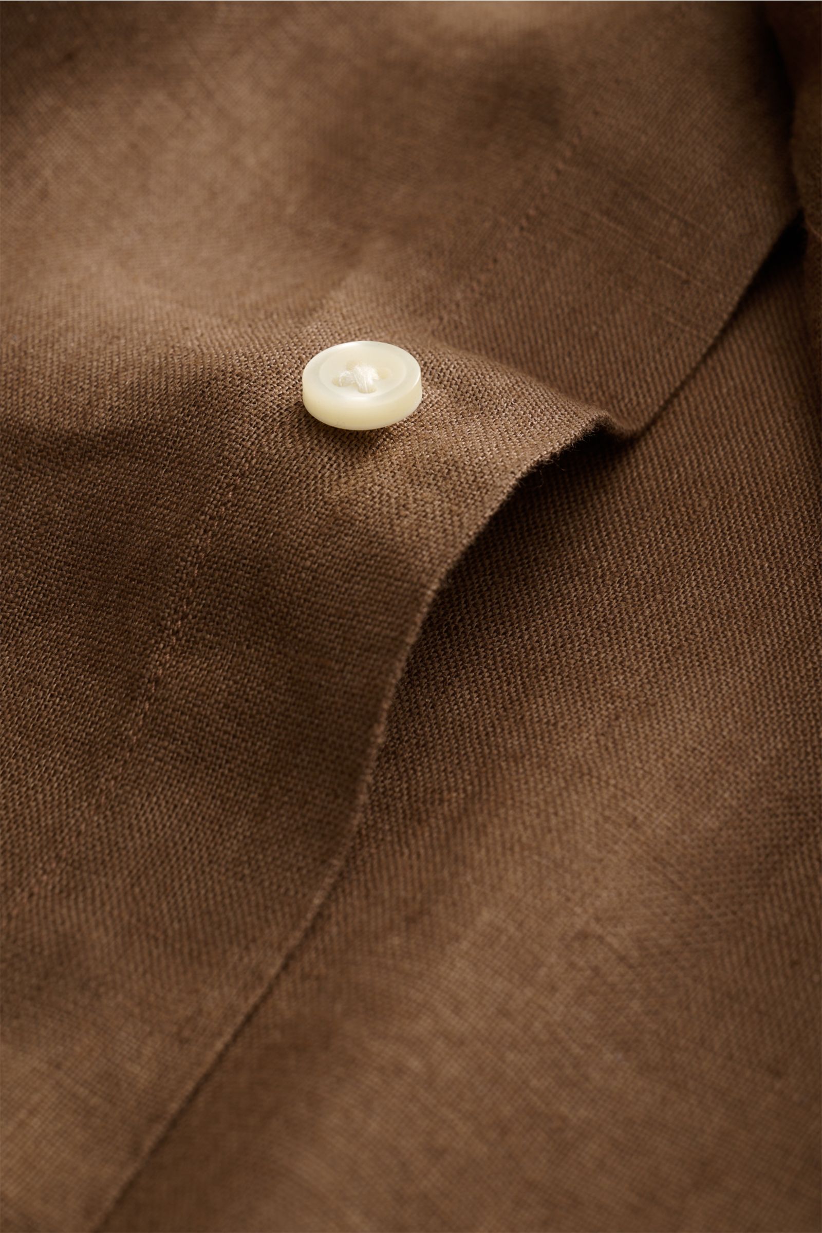 Close-up front perspective of Polo Ralph Lauren Leinenhemd Button-Down-Kragen braun showing brown linen fabric, button, and fine stitching.

Dieses Leinenhemd von POLO RALPH LAUREN ist eine Bereicherung für jede Sommergarderobe und bringt bei unverglei