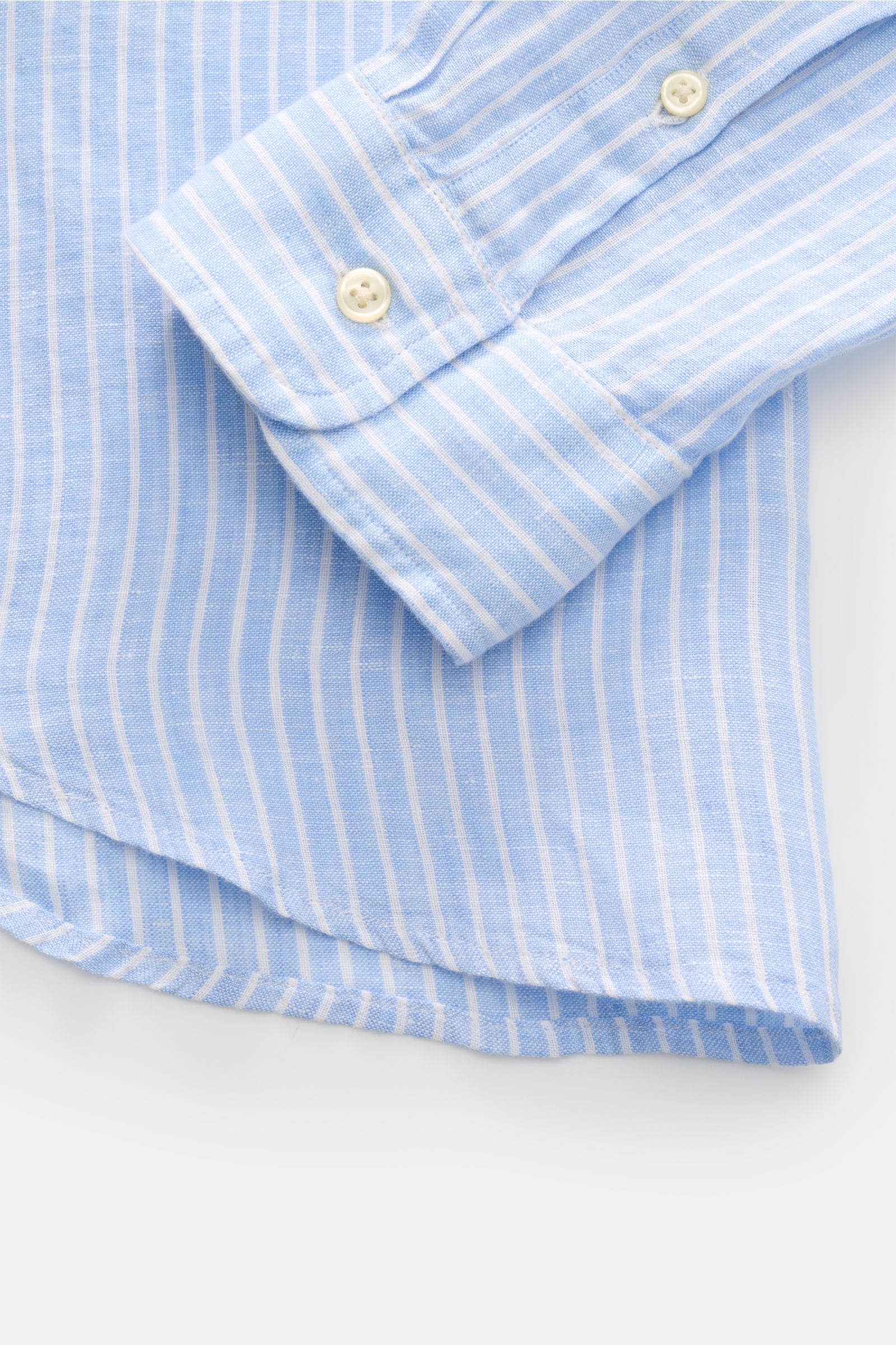 Close-up of Polo Ralph Lauren Linen shirt button-down collar light blue/white striped showing cuff and rounded hem from a top-down angle.

A summer classic from POLO RALPH LAUREN: This minimalist slim fit shirt in the finest linen with button-down coll