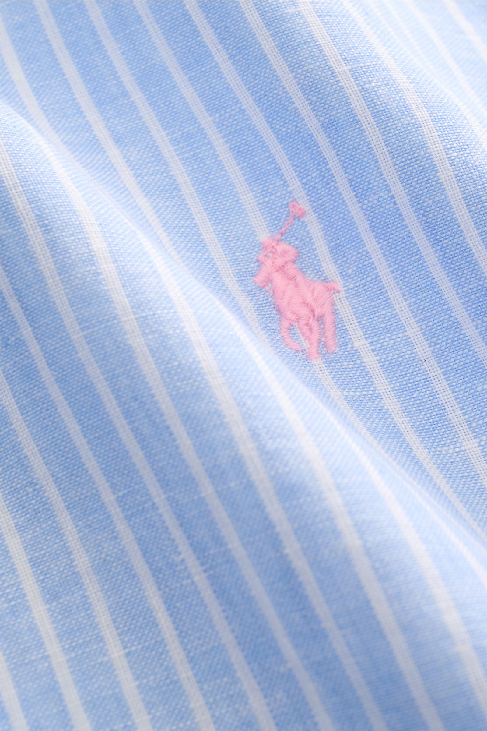 Close-up front view of Polo Ralph Lauren Linen shirt button-down collar light blue/white striped fabric with pink signature logo stitching, showing linen plain weave texture.

A summer classic from POLO RALPH LAUREN: This minimalist slim fit shirt in t