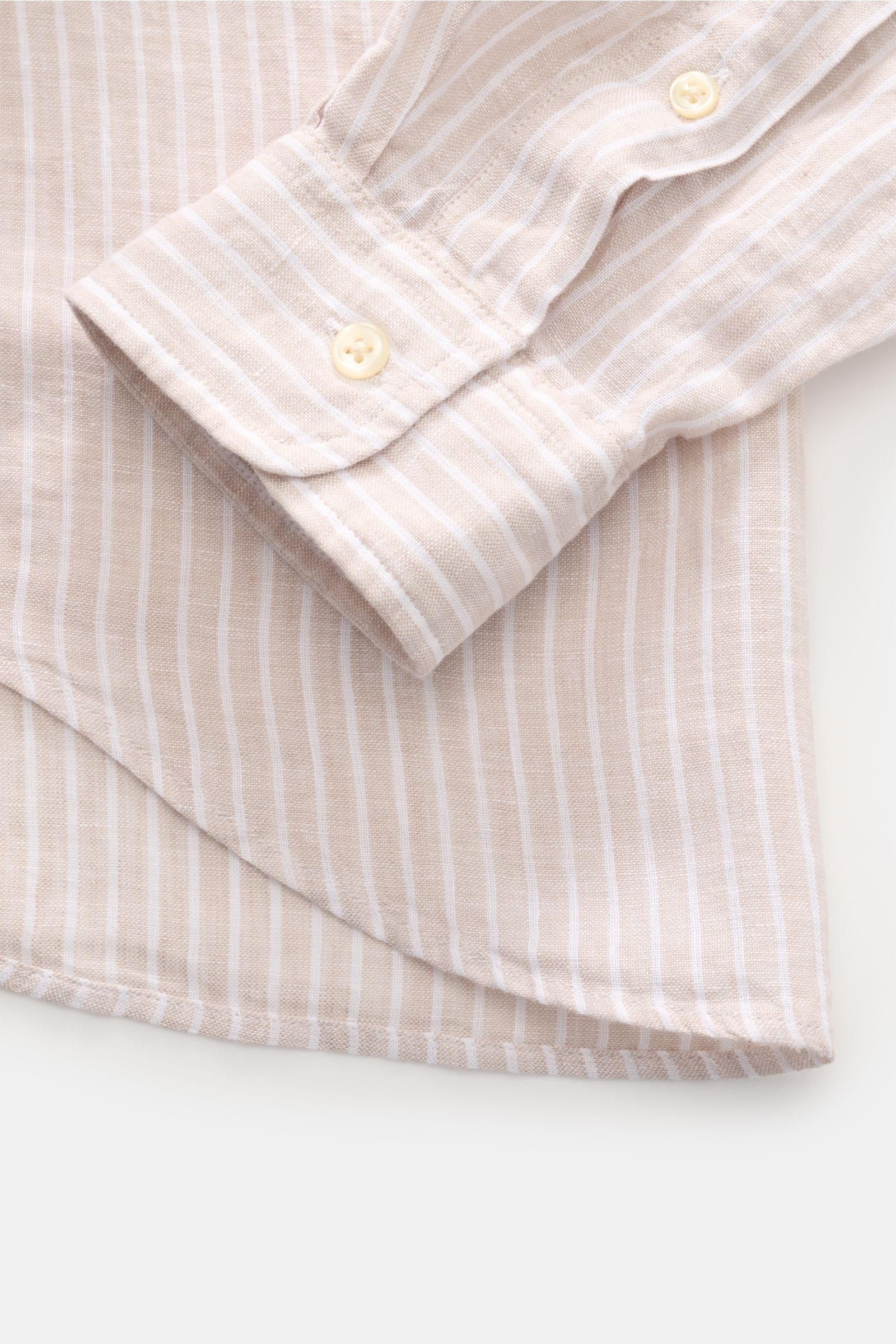Close-up front view of Polo Ralph Lauren Linen shirt button-down collar beige/white striped sleeve cuff with button and rounded hem.

A summer classic from POLO RALPH LAUREN: This minimalist slim fit shirt in the finest linen with button-down collar an