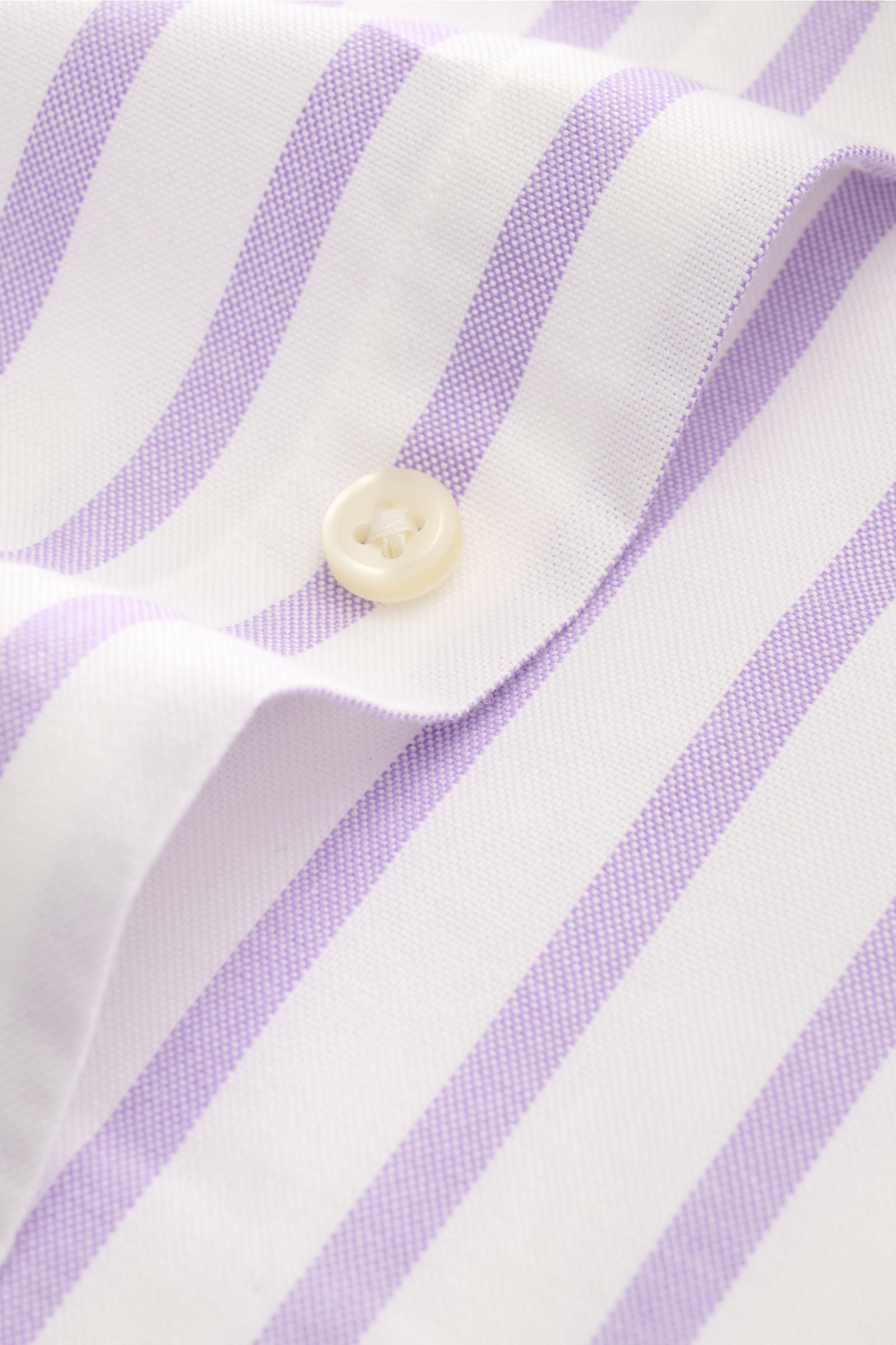 Close-up view of the Polo Ralph Lauren Casual Hemd Button-Down-Kragen flieder/weiß gestreift fabric, showing lilac and white stripes with a white button, highlighting the fine cotton texture and weave.

Stilvoll durch den Sommer: Das Slim-Fit-Hemd von 