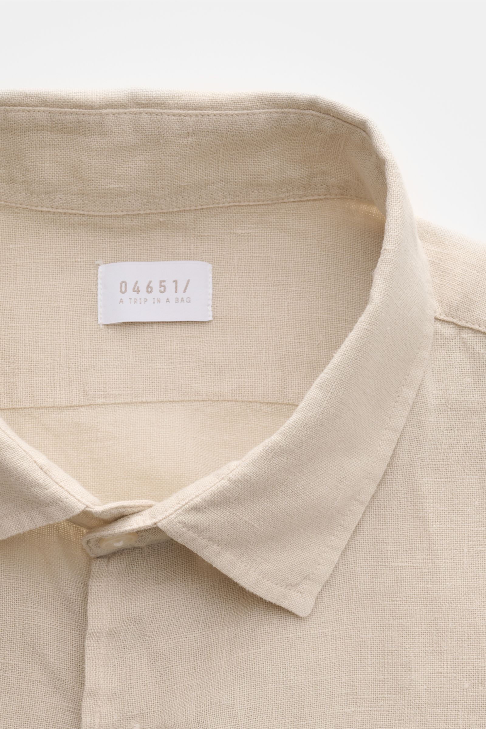Close-up front view of the collar and label of the 04651/ A trip in a bag Leinenhemd schmaler Kragen sand, made of pure linen with a slim collar.

Mühelose Leichtigkeit