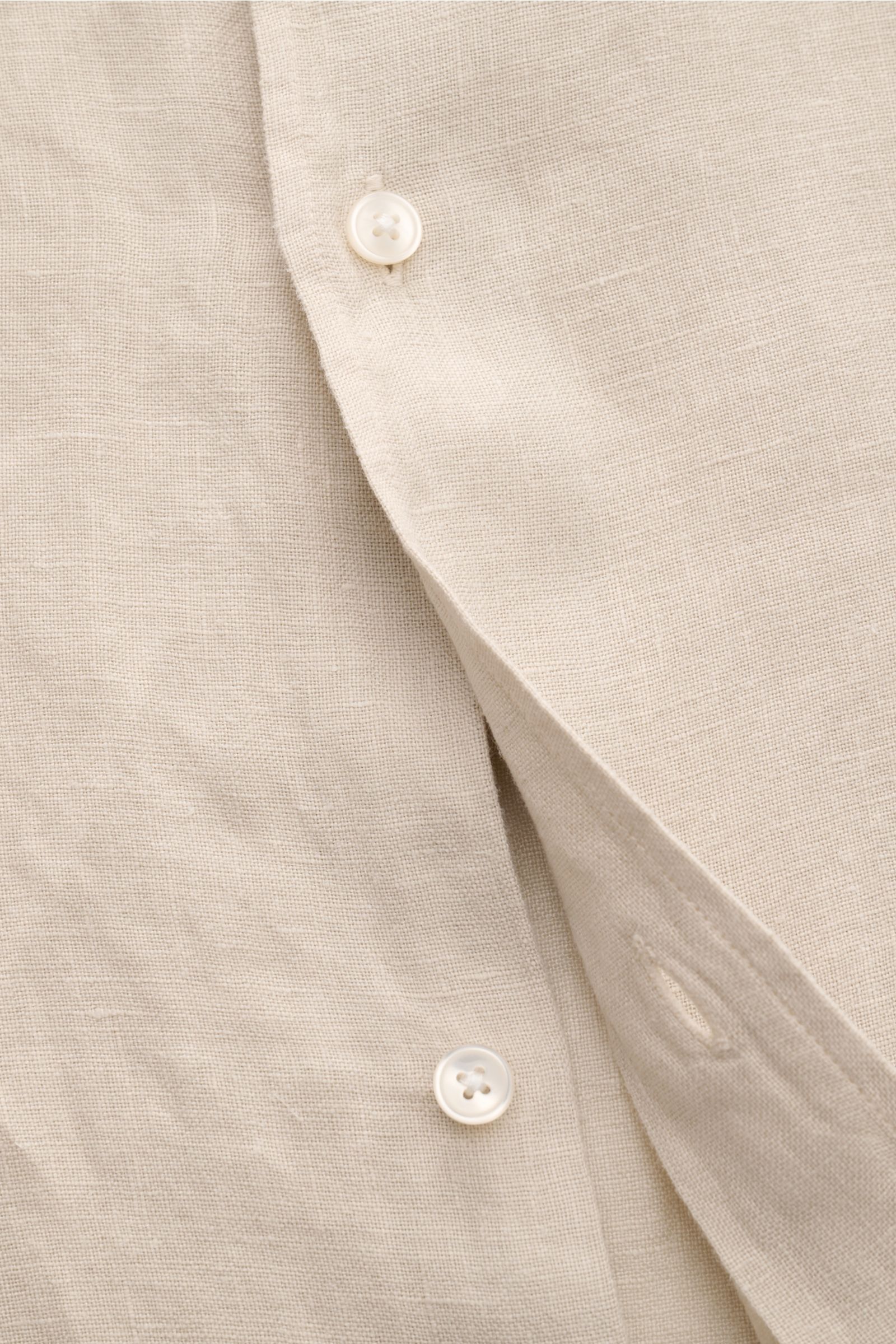Close-up front view of the sand-colored 04651/ A trip in a bag Leinenhemd schmaler Kragen sand, showing linen texture and white buttons. Mühelose Leichtigkeit