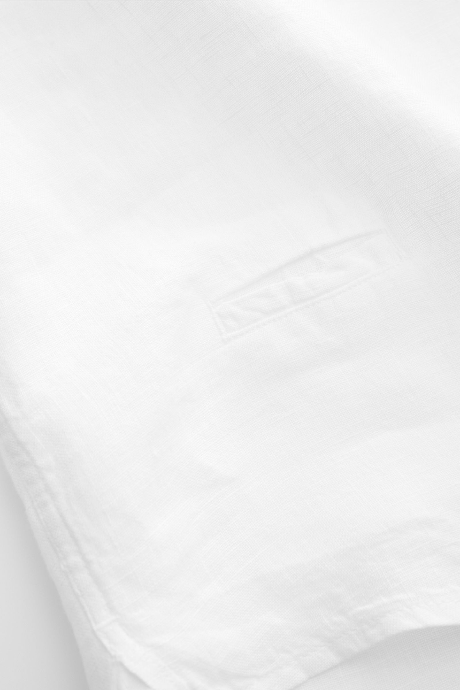 04651/ A trip in a bag Leinenhemd schmaler Kragen weiß, Detailfoto von unten, reines Leinen mit luftiger Struktur, leichter Saum, Weblabel.