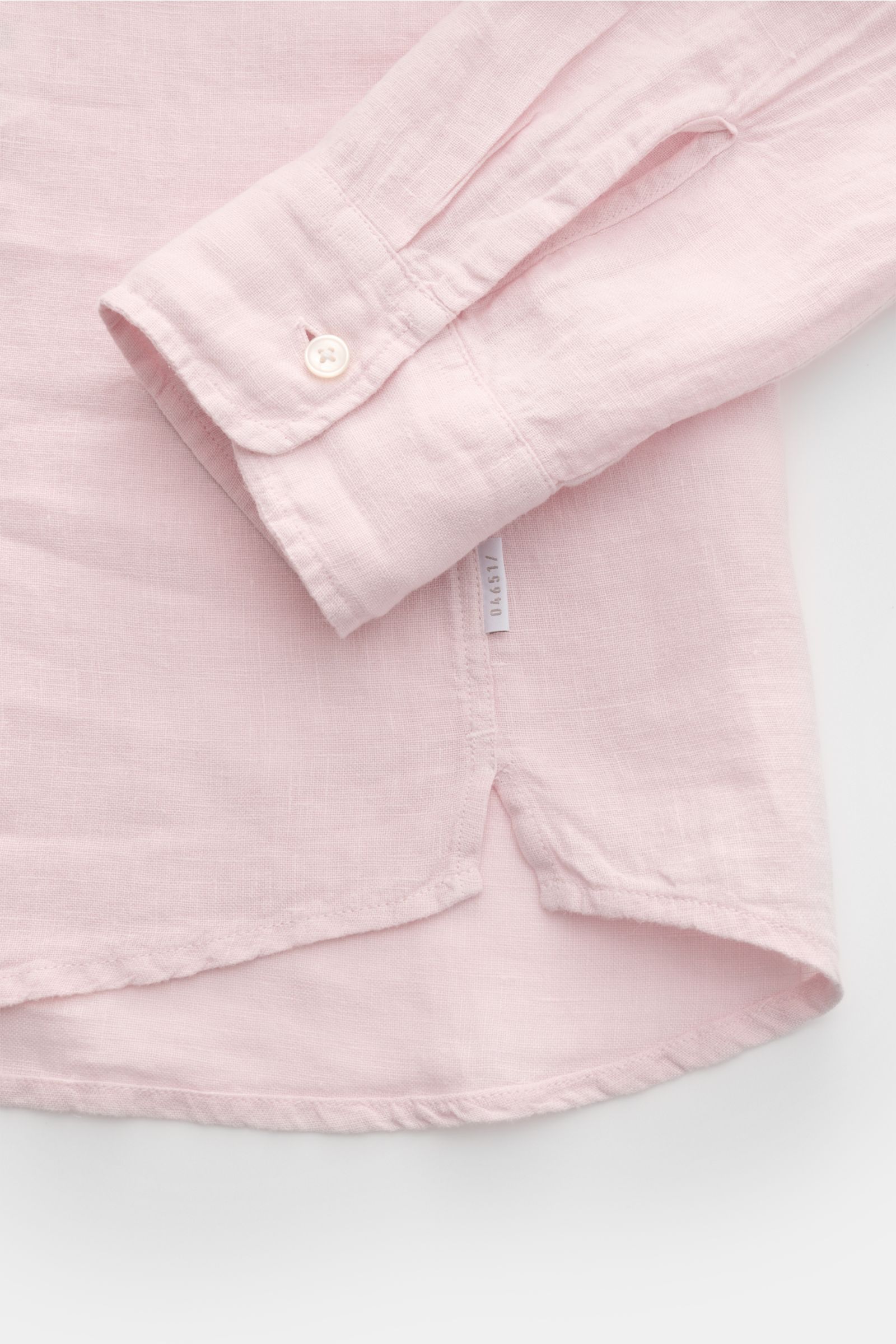Close-up view of the cuff and hem of the 04651/ A trip in a bag Leinenhemd schmaler Kragen rosé, showing its airy pink linen fabric and fine details.

Mühelose Leichtigkeit