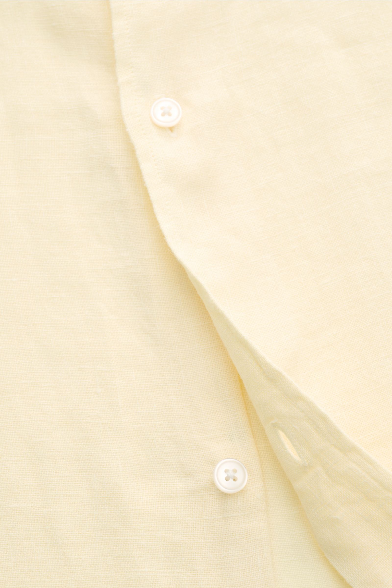 Close-up front view of 04651/ A trip in a bag Linen shirt narrow collar pastel yellow in pure linen with French button placket and airy texture. 

Effortless lightness