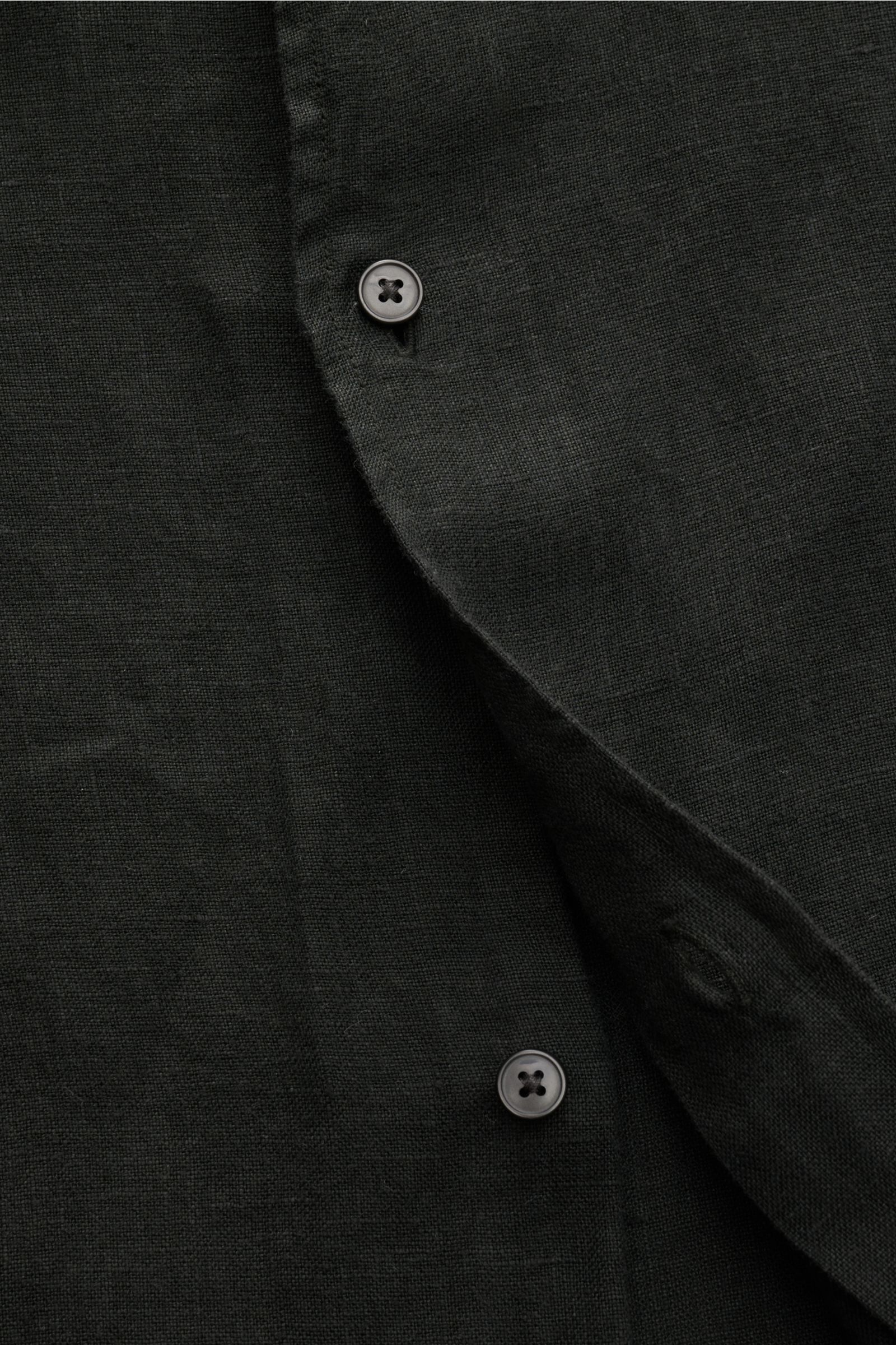 Close-up front view of the black 04651/ A trip in a bag Leinenhemd schmaler Kragen schwarz, showing detailed linen fabric texture and button fastening. Mühelose Leichtigkeit