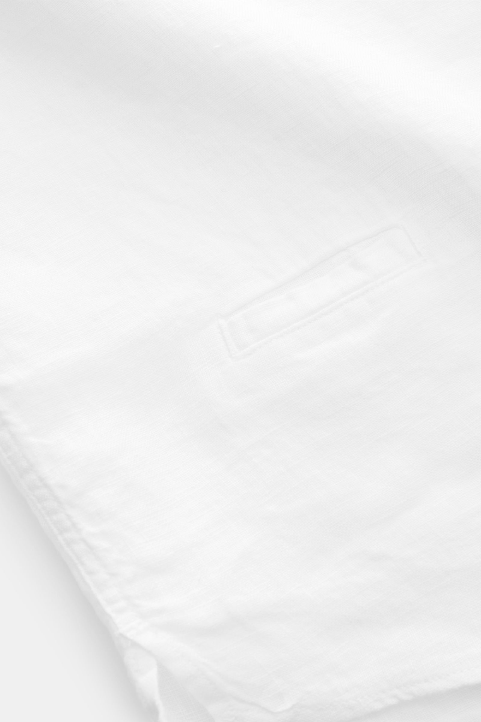 Close-up top-down view of the small welt pocket on the 04651/ A trip in a bag Linen shirt 'Linen Guru' grandad collar white made of pure linen fabric.

Summer for your skin: The airy casual shirt 'Linen Guru' by 04651/ A TRIP IN A BAG is made of pure l