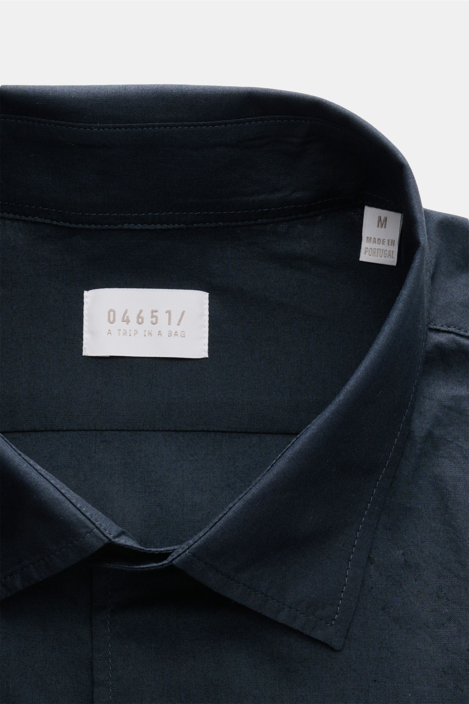 Close-up front view of the collar and label of 04651/ A trip in a bag Casual shirt 'Cloudy Shirt' slim collar navy in lightweight pure cotton.

Lightweight and comfortable for hot days: The casual shirt 'Cloudy Shirt' by 0