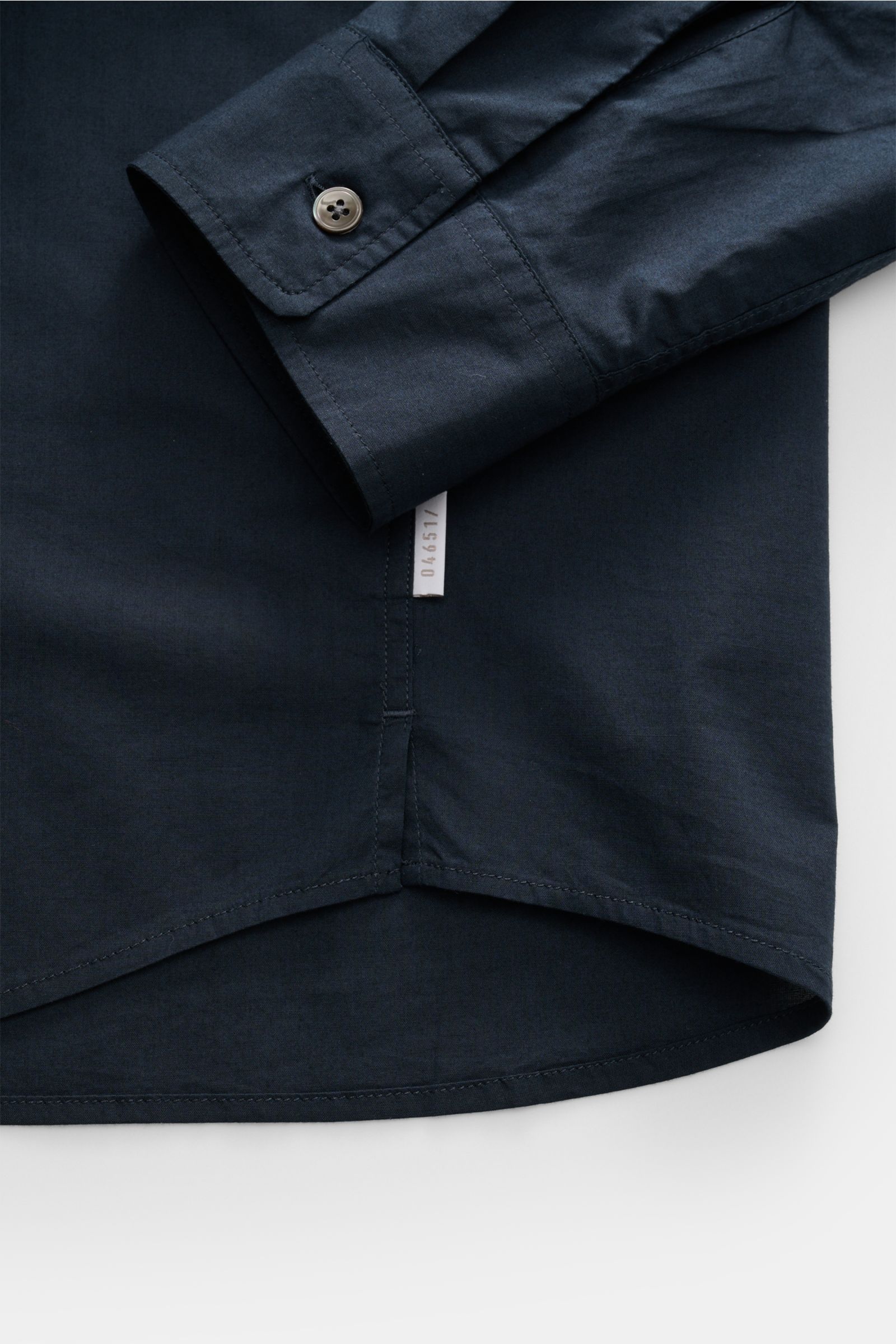 Alt tag (125 characters):
Close-up of cuff and hem of 04651/ A trip in a bag Casual shirt 'Cloudy Shirt' slim collar navy, showing fabric texture and label.

Description:
Lightweight and comfortable for hot days: The casua