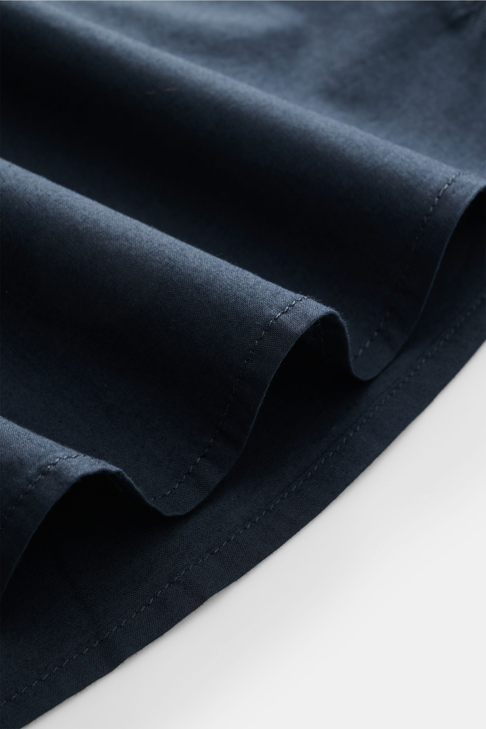 Alt tag (125 characters max):
Close-up angled view of navy fabric folds of 04651/ A trip in a bag Casual shirt 'Cloudy Shirt' slim collar navy.

Additional detailed description:
Lightweight and comfortable for hot days: Th