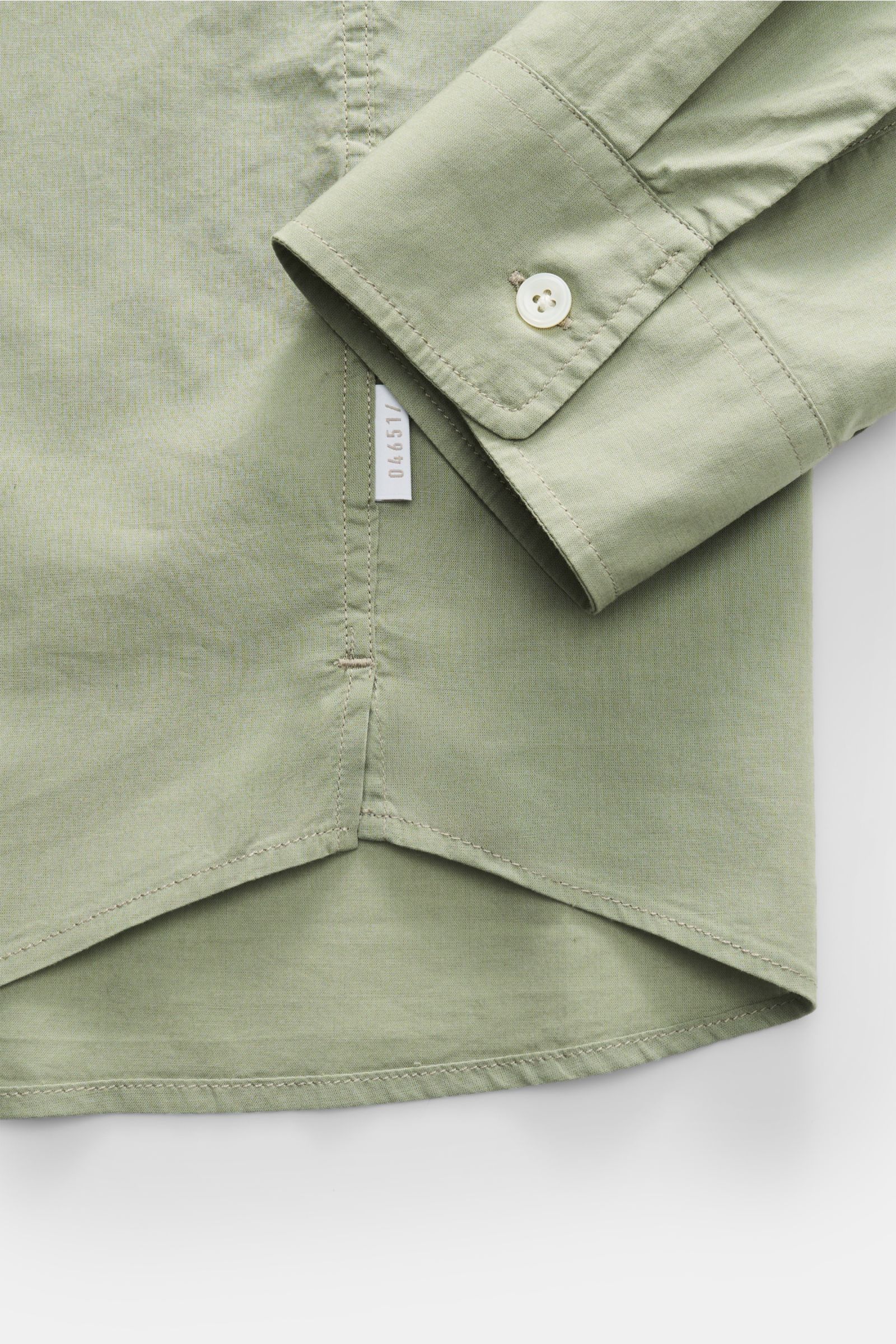 Close-up view of the cuff and hem of the 04651/ A trip in a bag Casual shirt 'Cloudy Shirt' slim collar sage in light green cotton fabric.

Lightweight and comfortable for hot days: The casual shirt 'Cloudy Shirt' by 04651