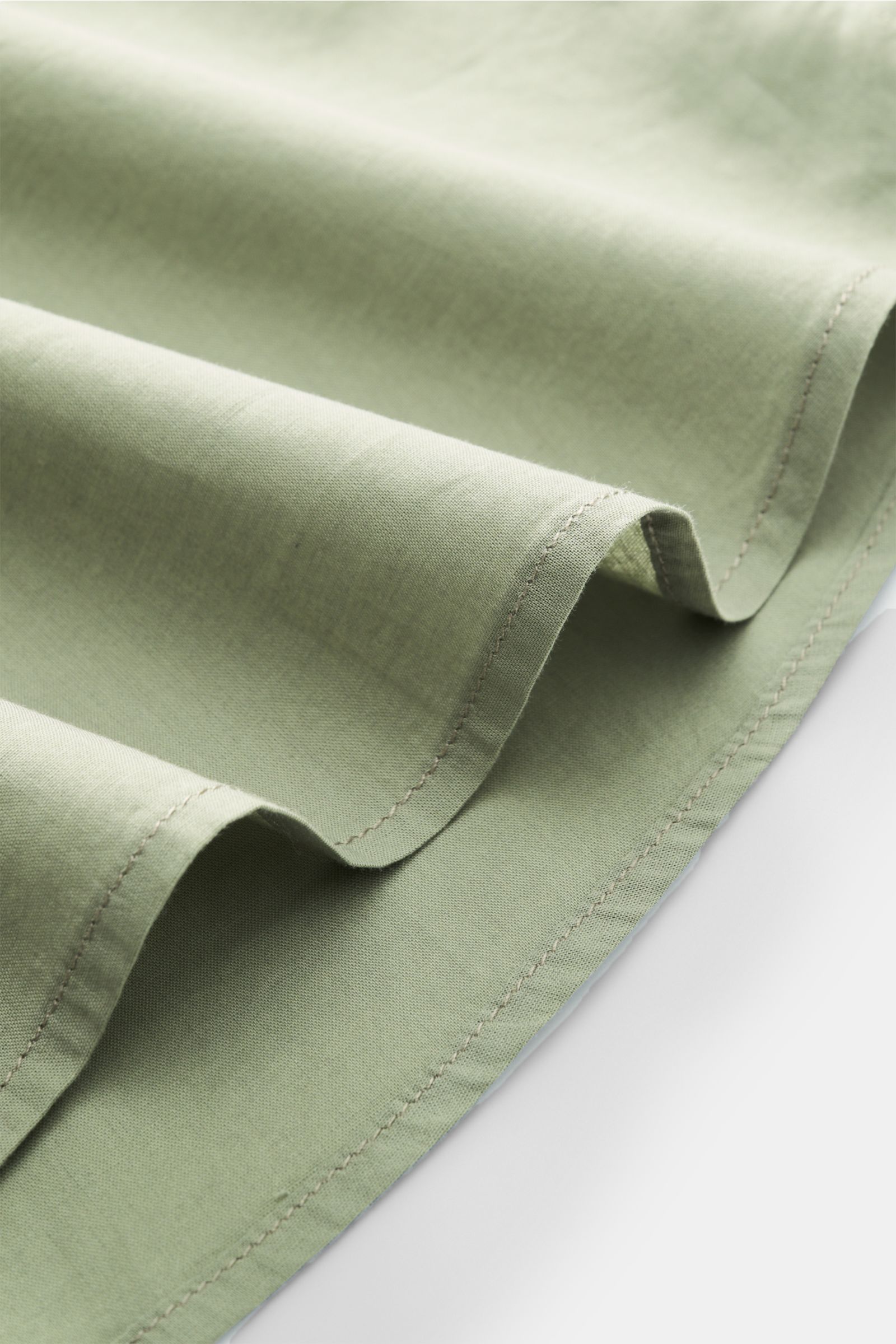 Alt tag (125 characters max):
Close-up fabric folds of 04651/ A trip in a bag Casual shirt 'Cloudy Shirt' slim collar sage, showing texture and stitching detail.

Description:
Lightweight and comfortable for hot days: The 