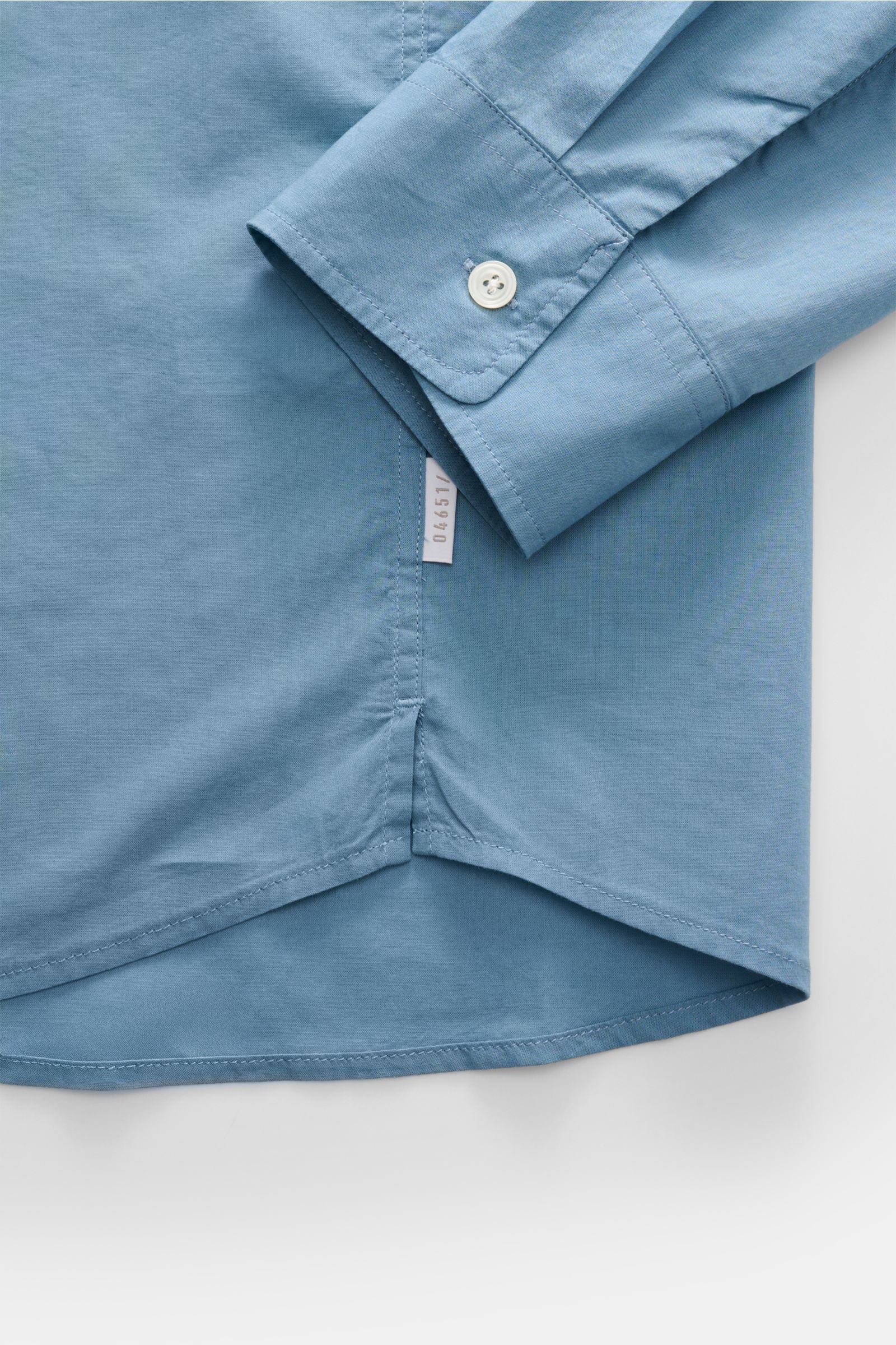 Close-up top view of the cuff and hem of the 04651/ A trip in a bag Casual shirt 'Cloudy Shirt' slim collar smoky blue in lightweight cotton.

Lightweight and comfortable for hot days: The casual shirt 'Cloudy Shirt' by 04