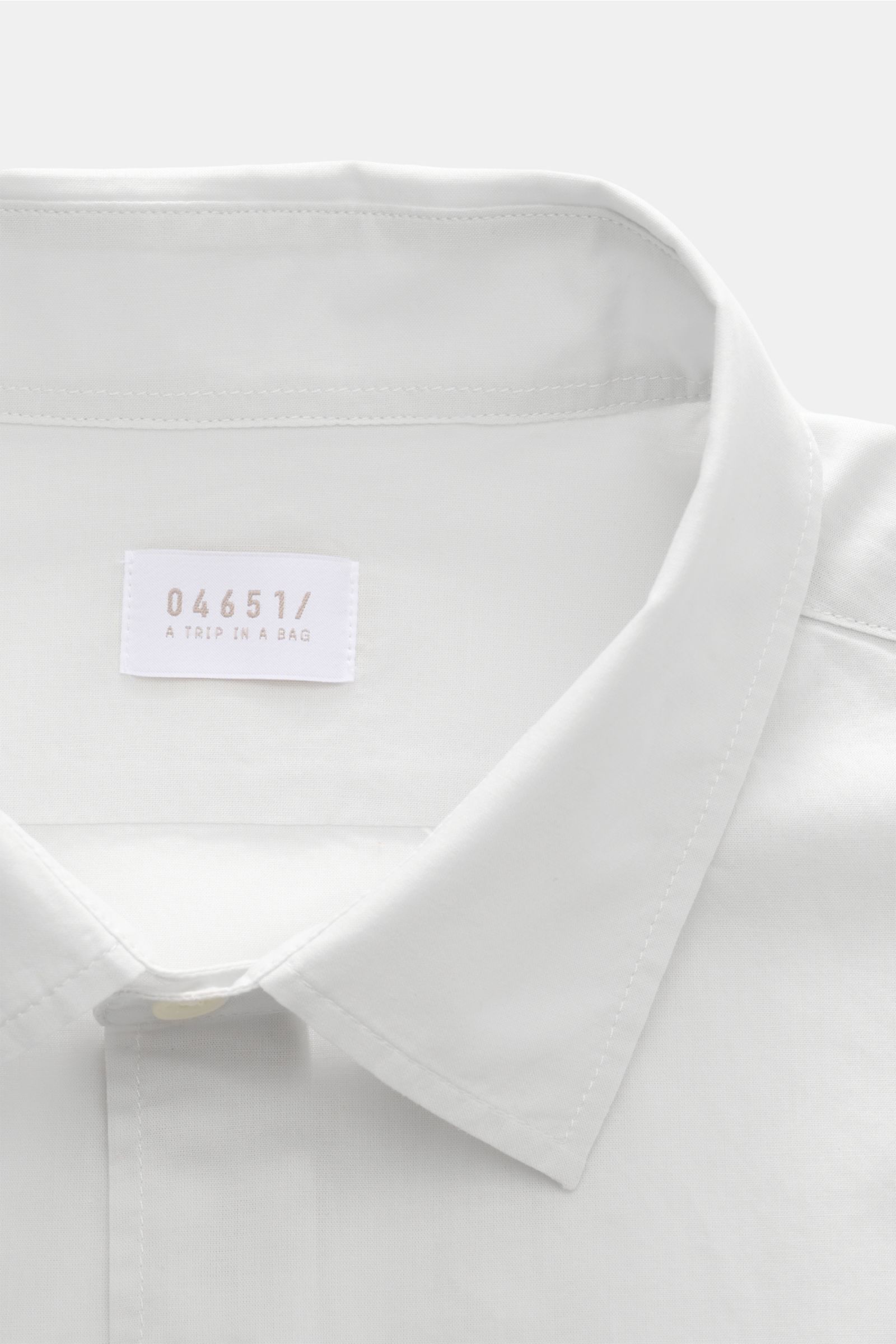 Close-up front view of the collar and label of the 04651/ A trip in a bag Casual shirt 'Cloudy Shirt' slim collar light grey.

Lightweight and comfortable for hot days: The casual shirt 'Cloudy Shirt' by 04651/ A TRIP IN A
