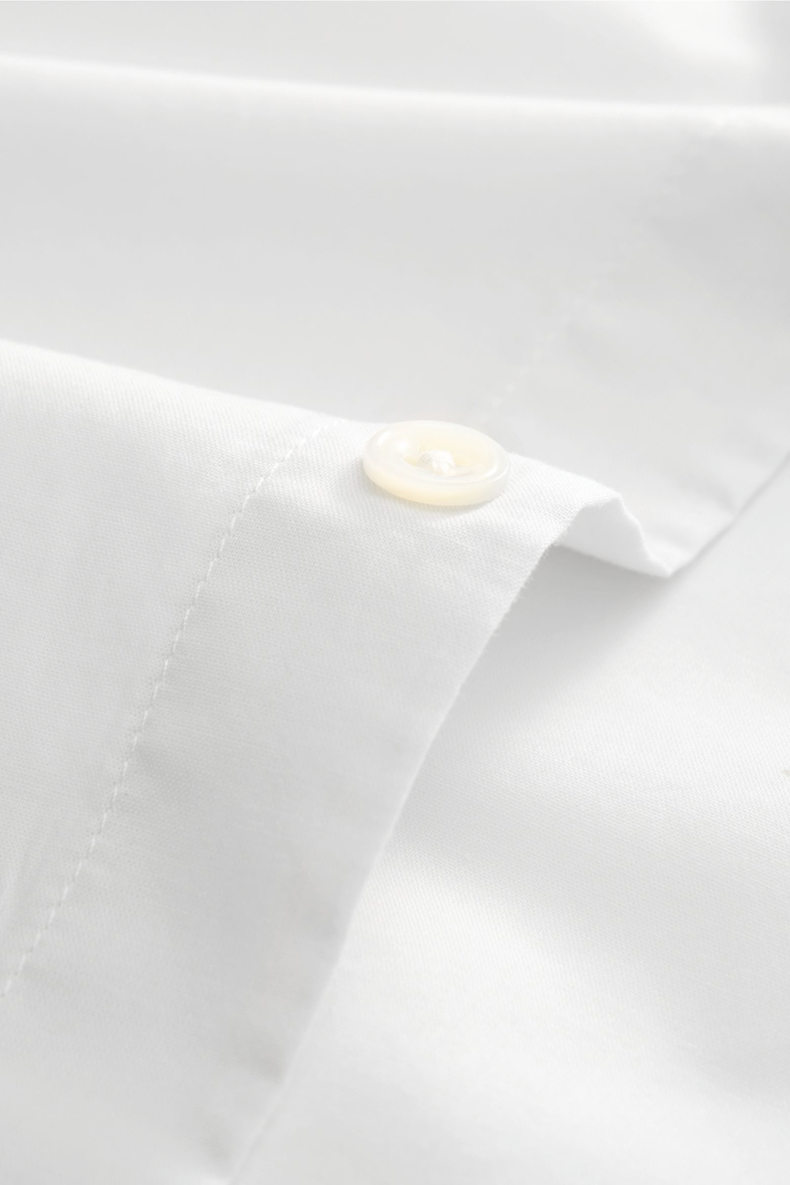 Close-up front perspective of 04651/ A trip in a bag Casual shirt 'Cloudy Shirt' slim collar light grey showing white fabric and a pearl button on the cuff.

Lightweight and comfortable for hot days: The casual shirt 'Clou