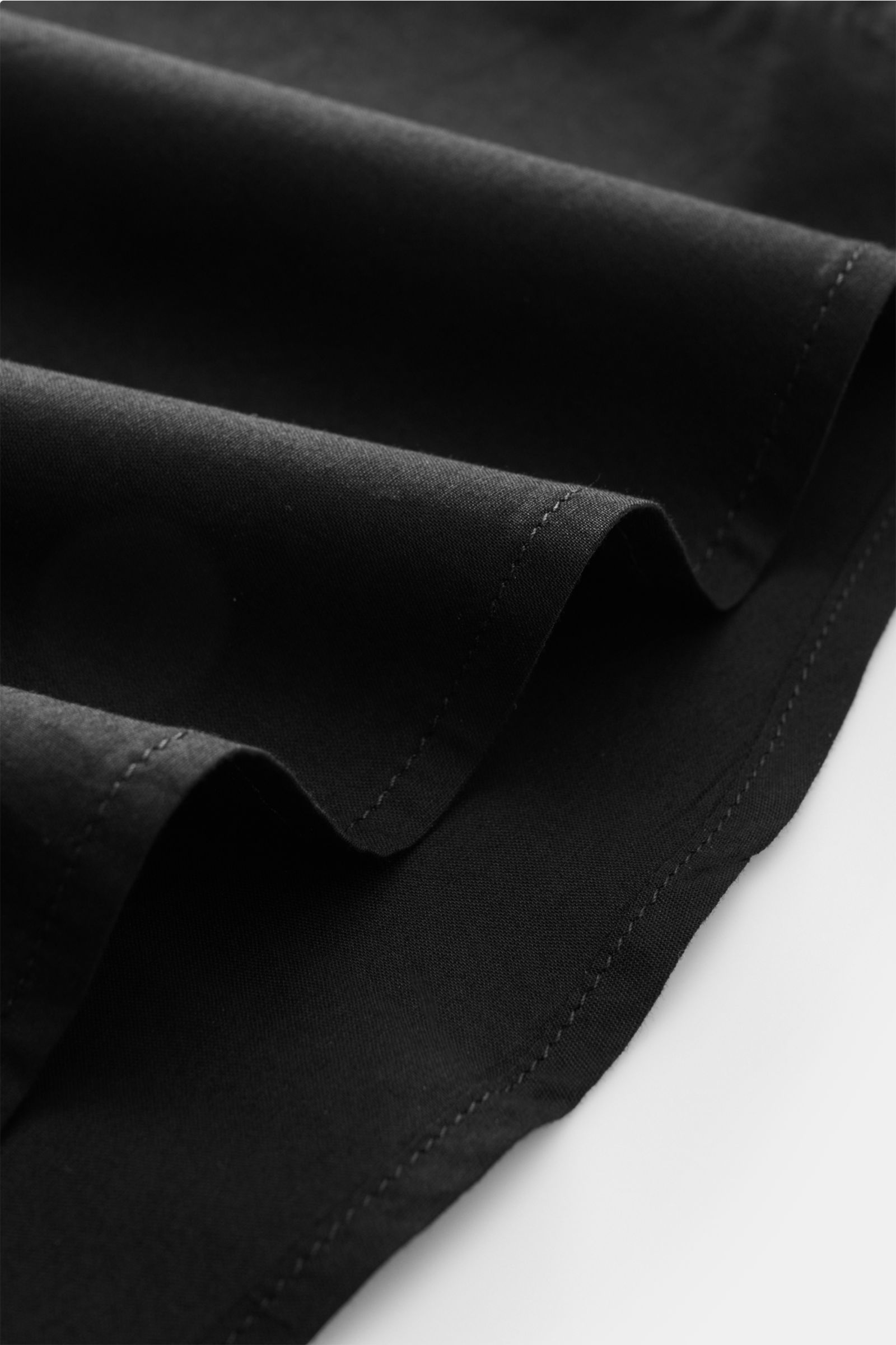 Schwarzes 04651/ A trip in a bag Casual Hemd 'Cloudy Shirt' mit schmalem Kragen, leichte Baumwolle, Detailaufnahme des Saums aus seitlicher Perspektive.