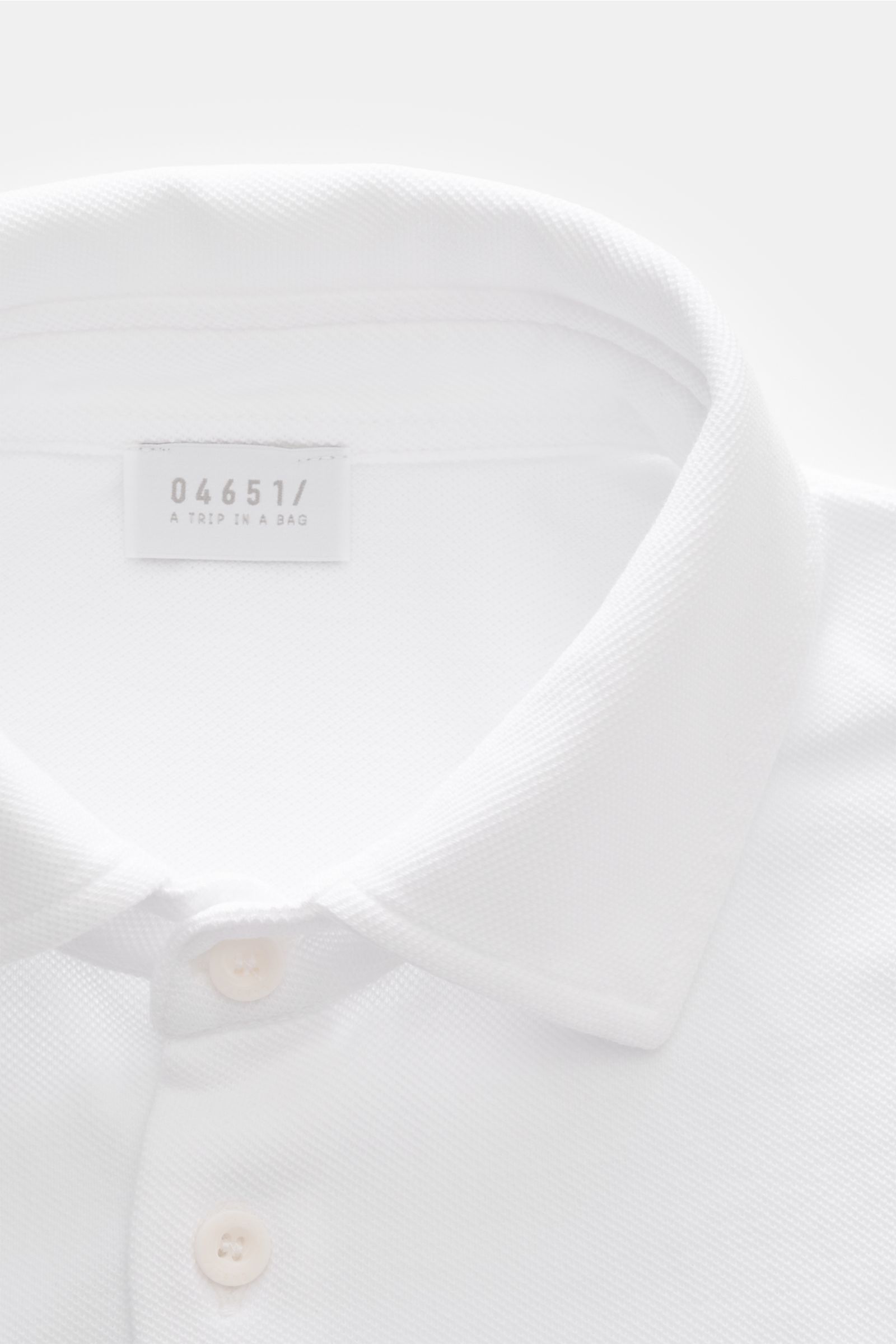 Close-up front view of the 04651/ A trip in a bag Piqué shirt slim collar white, showcasing narrow collar, French button placket, and fine piqué texture. Casual everyday basic by 04651/ A TRIP IN A BAG: This casual shirt in pure cotton piqué has an att
