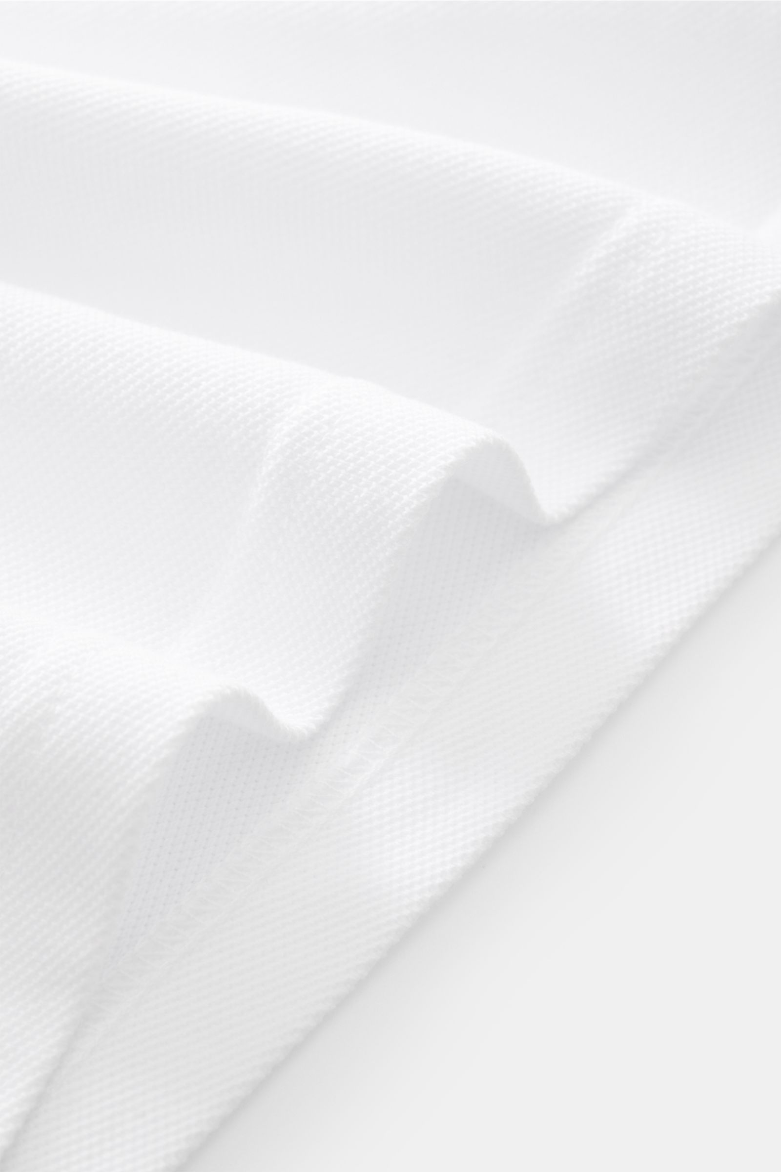 Close-up angled view of the white 04651/ A trip in a bag Piqué shirt slim collar white fabric showing pure cotton piqué texture with garment-dyed finish.  

Casual everyday basic by 04651/ A TRIP IN A BAG: This casual shirt in pure cotton piqué has an 