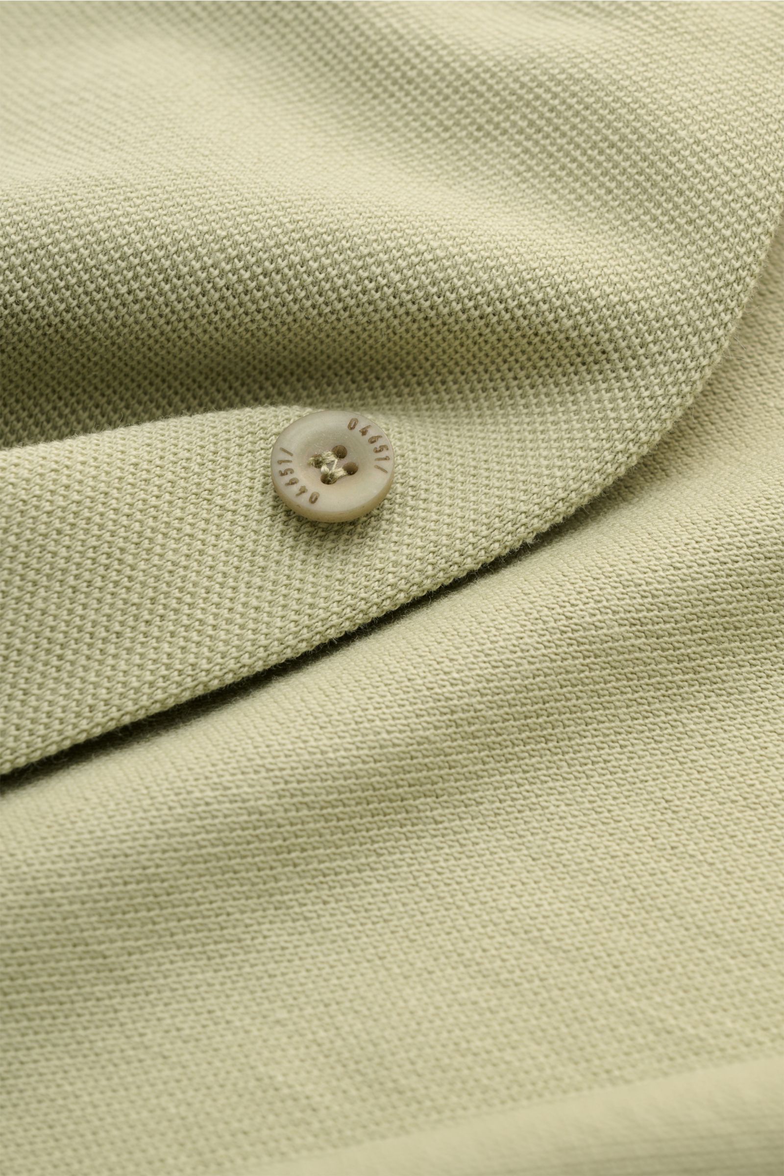 Close-up front view of the 04651/ A trip in a bag Piqué shirt slim collar sage showing the fine piqué texture and a button with '04651/' engraving on pure cotton fabric.

Casual everyday basic by 04651/ A TRIP IN A BAG: This casual shirt in pure cotton