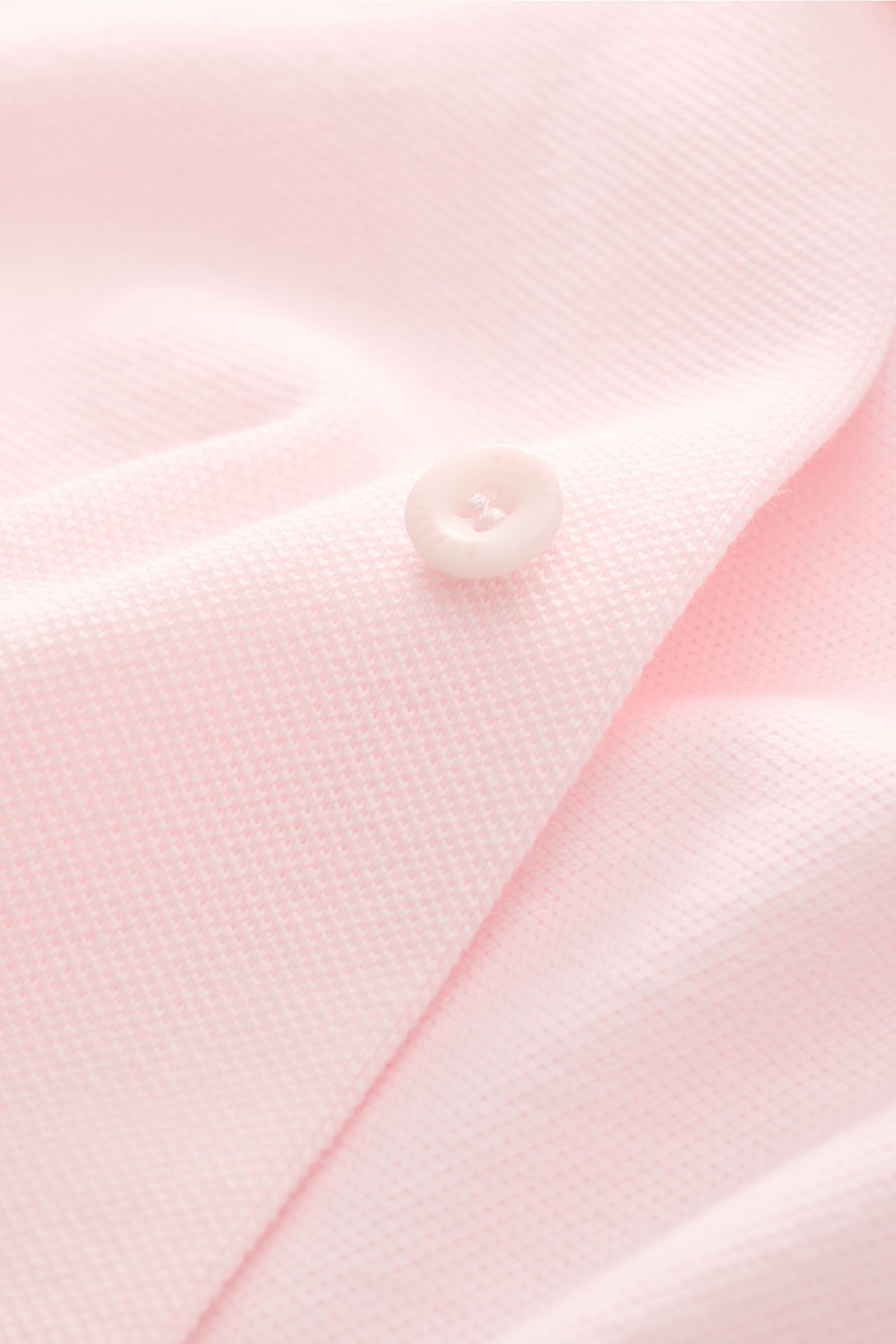 Close-up front view of the 04651/ A trip in a bag Piqué shirt slim collar rose showing the fine piqué texture and white button on soft pink pure cotton fabric. Casual everyday basic by 04651/ A TRIP IN A BAG: This casual shirt in pure cotton piqué has an 