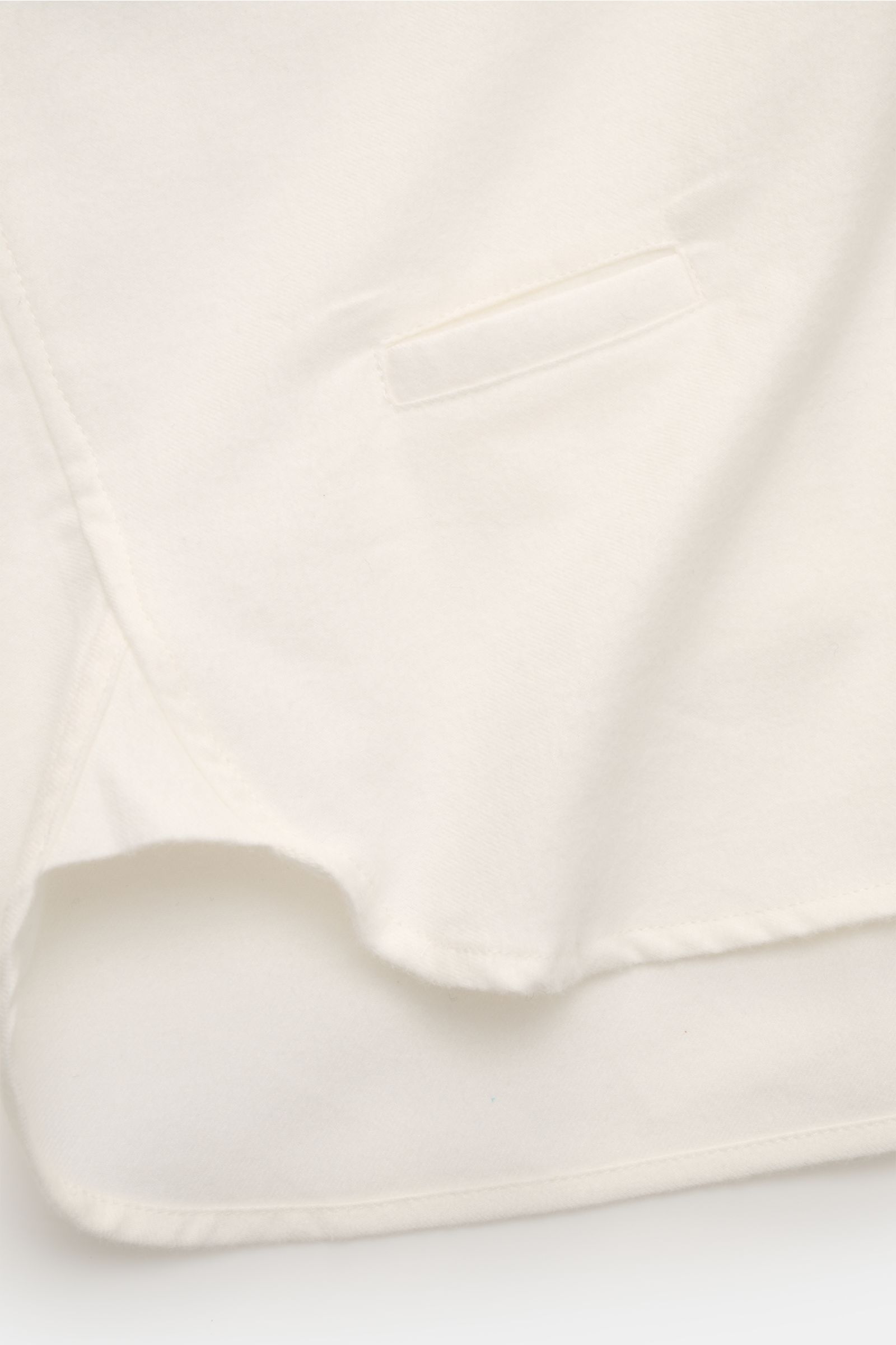 04651/ A trip in a bag Flanellhemd Button-Down-Kragen offwhite, Detailaufnahme Saumverlauf und paspelierte Tasche aus reiner Baumwolle mit weichem Griff.