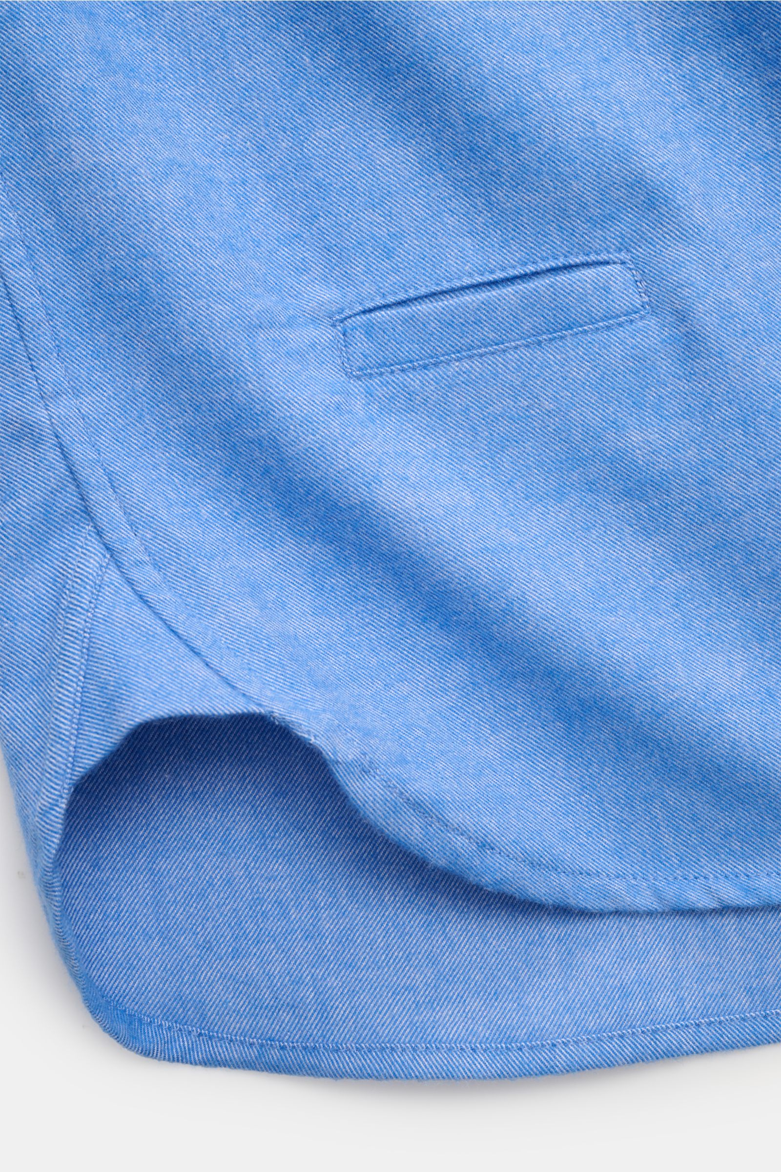 Close-up front-side view of the hem and small welt pocket of the 04651/ A trip in a bag Flanellhemd Button-Down-Kragen blau meliert, made of pure cotton with a soft touch and classic sporty details. Exklusiver Tragekomfort für die Übergangszeit: Das Flane