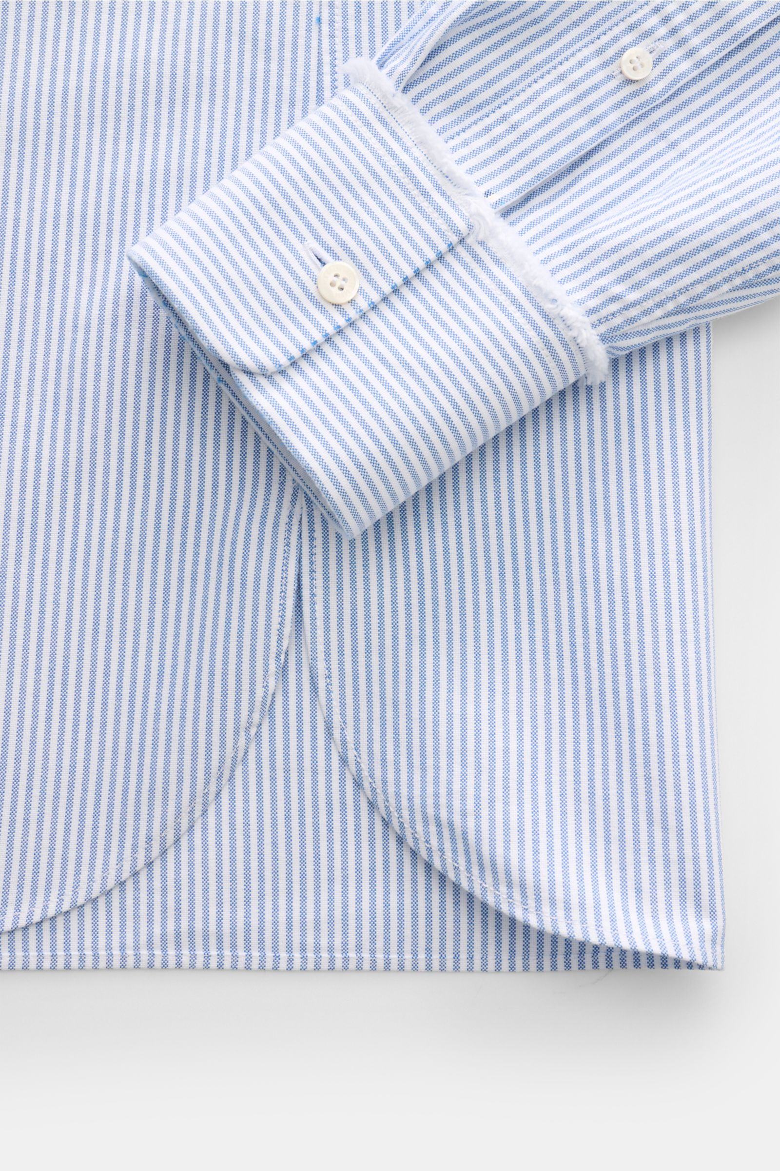 Close-up front view of the Golden Goose Oxford-Hemd Kent-Kragen blau/weiß gestreift showing its blue and white striped cotton fabric, slim fit cuff with button, and rounded hem.

Modernes Essential mit Signature-Attitüde: Das Baumwollhemd von GOLDEN GO
